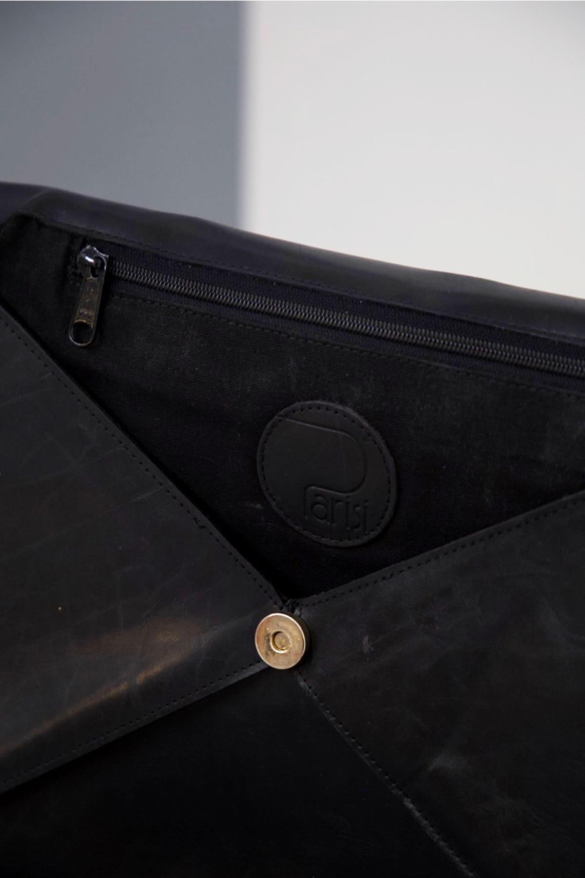 Schwarze Vintage-Clutch-Tasche aus Leder, entworfen von Parisi in den 1990er Jahren, hergestellt in Italien.
Die Clutch-Tasche ist ganz aus schwarzem Leder, Clutch-Stil, rechteckige Form mit Dreieck Öffnung, sehr charmant.
Die Tasche öffnet sich