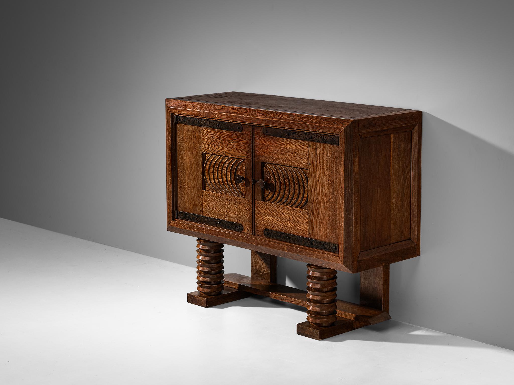 Georges & Gaston Guérin, cabinet, solid oak, iron, Paris, France, 1930s/40s

Made in Paris, this sideboard is designed according to the French Art Deco design principles that rose to prominence in the 1930s and 1940s. This credenza clearly shows