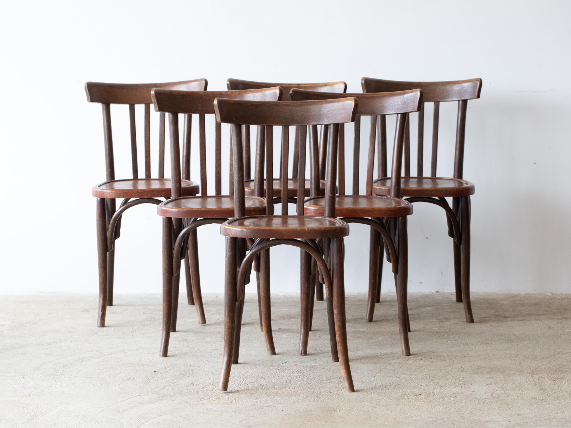 A set of six stained beech Parisian bistro chairs. French, mid 20C.

Stock ref. #2289

Two chairs retain their Raymond Coppin, Vincennes maker's plaque. 

All structurally sound and in their original well-worn finish. Cleaned and waxed in-house.