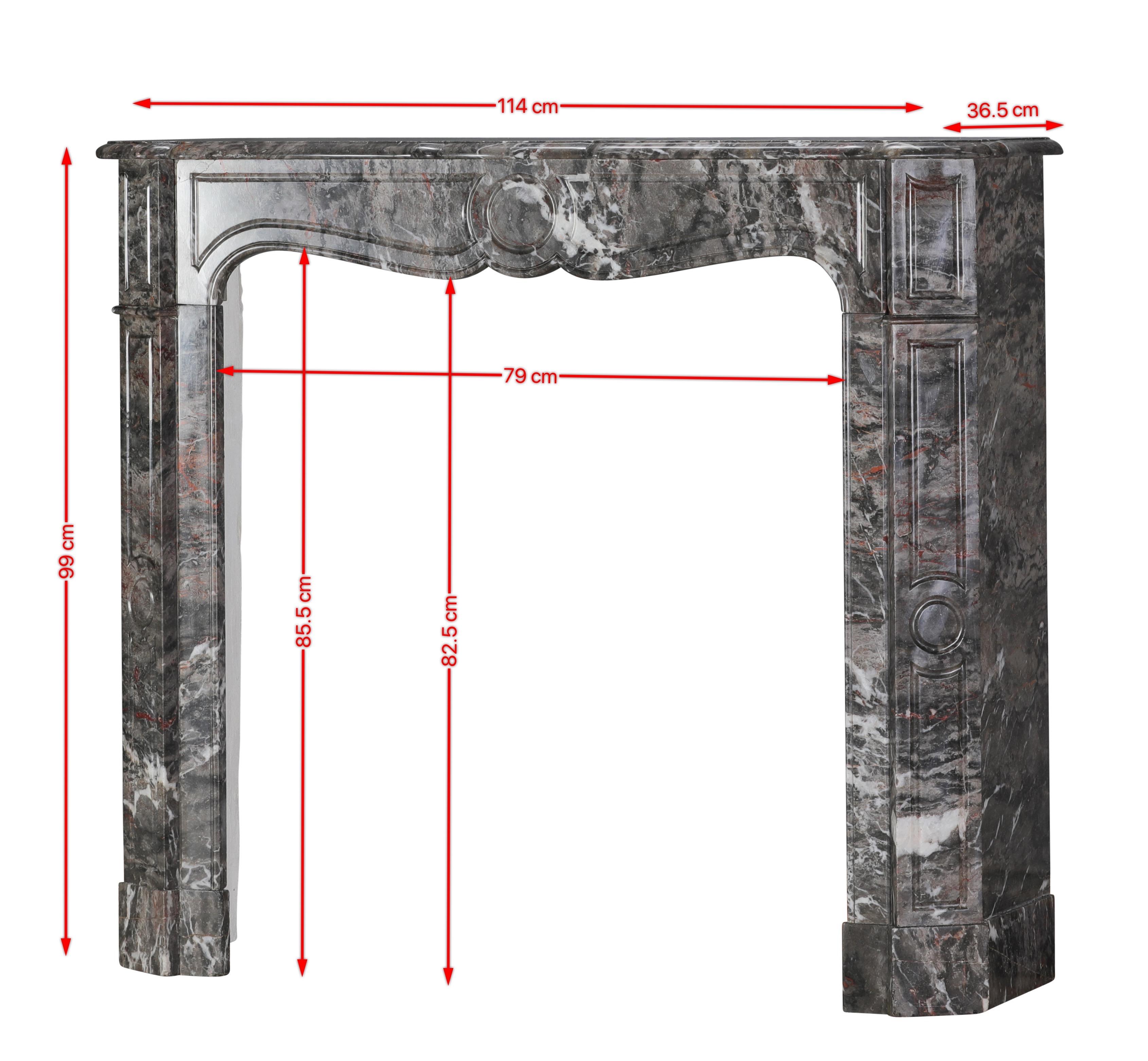 Questo autentico camino francese Pompadour del XIX secolo è realizzato con il ricercatissimo marmo Bois Jourdan, una delle pietre più caratteristiche e ricche di colore della Francia. La sua palette espressiva - grigi profondi, calde venature rosso