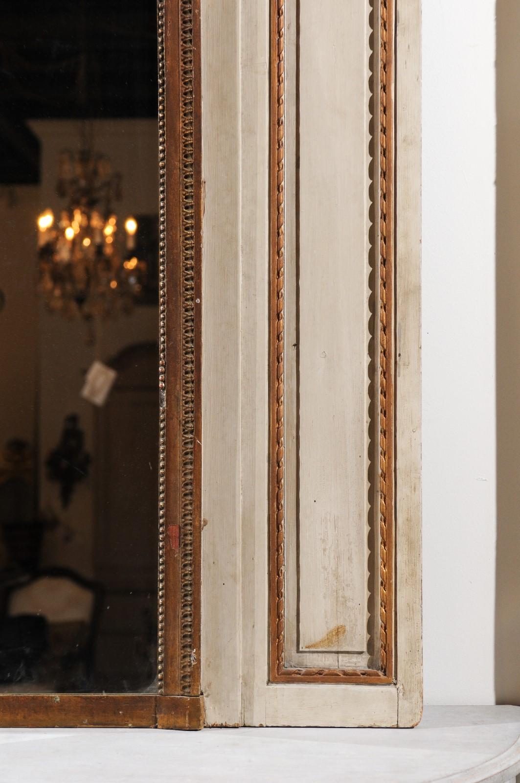 Miroir à trumeau en bois peint de style Louis XVI, datant du milieu du XIXe siècle, avec des instruments de musique. Né à Paris sous le règne de l'empereur Napoléon III, ce miroir à trumeau peint présente les caractéristiques stylistiques de