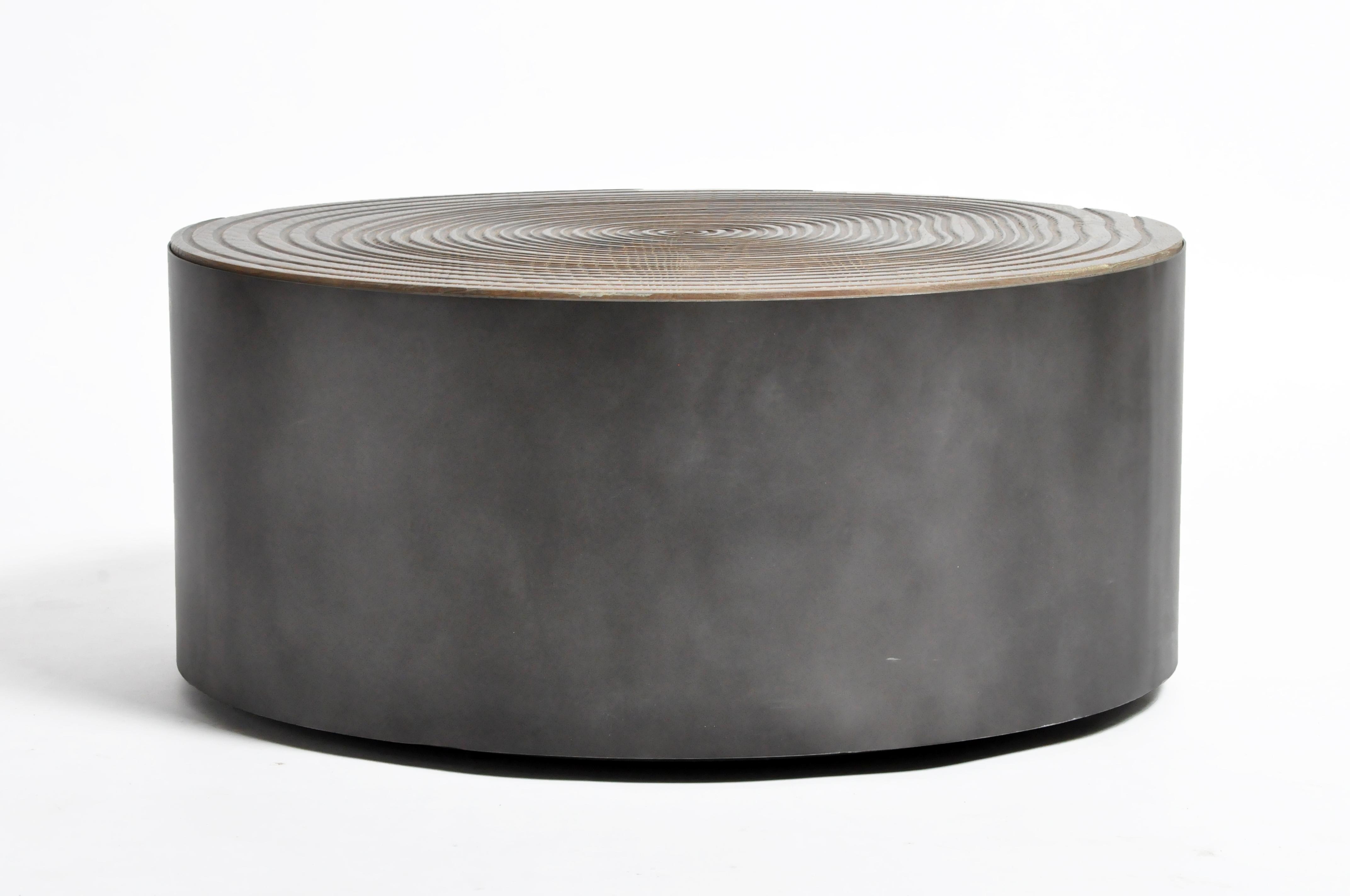 This newly made round coffee table is from France, and made from oakwood and metal, circa 21st century. The table features a modern metal base with carved tree ring-styled whorls.