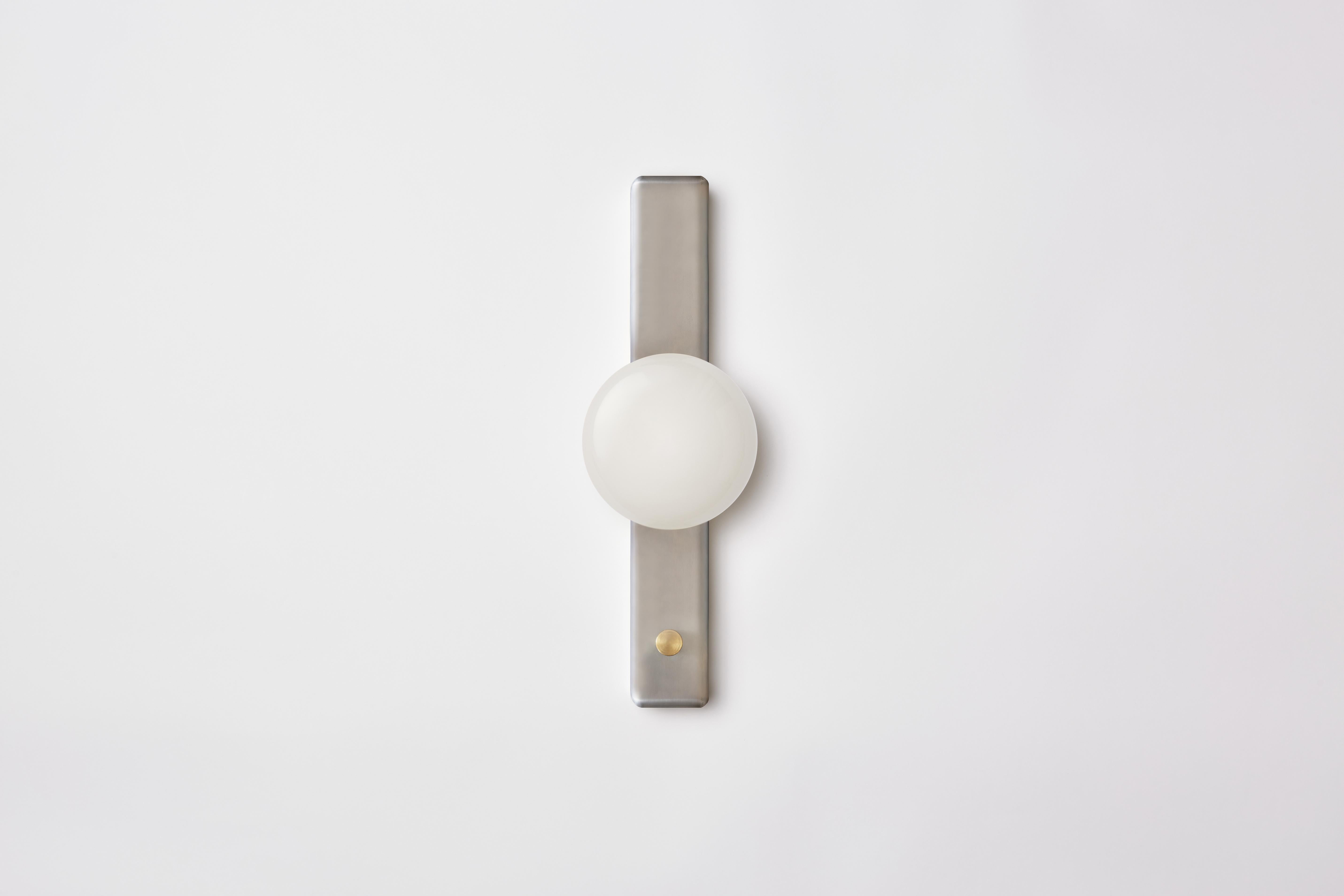 Park II incorporates a dome-shaped glass shade, set against a slender enamel form. Referencing porcelain fixtures produced during the pre-war period, Park II is an iconic sconce for modern-day use. This fixture is designed to fit over a rectangular