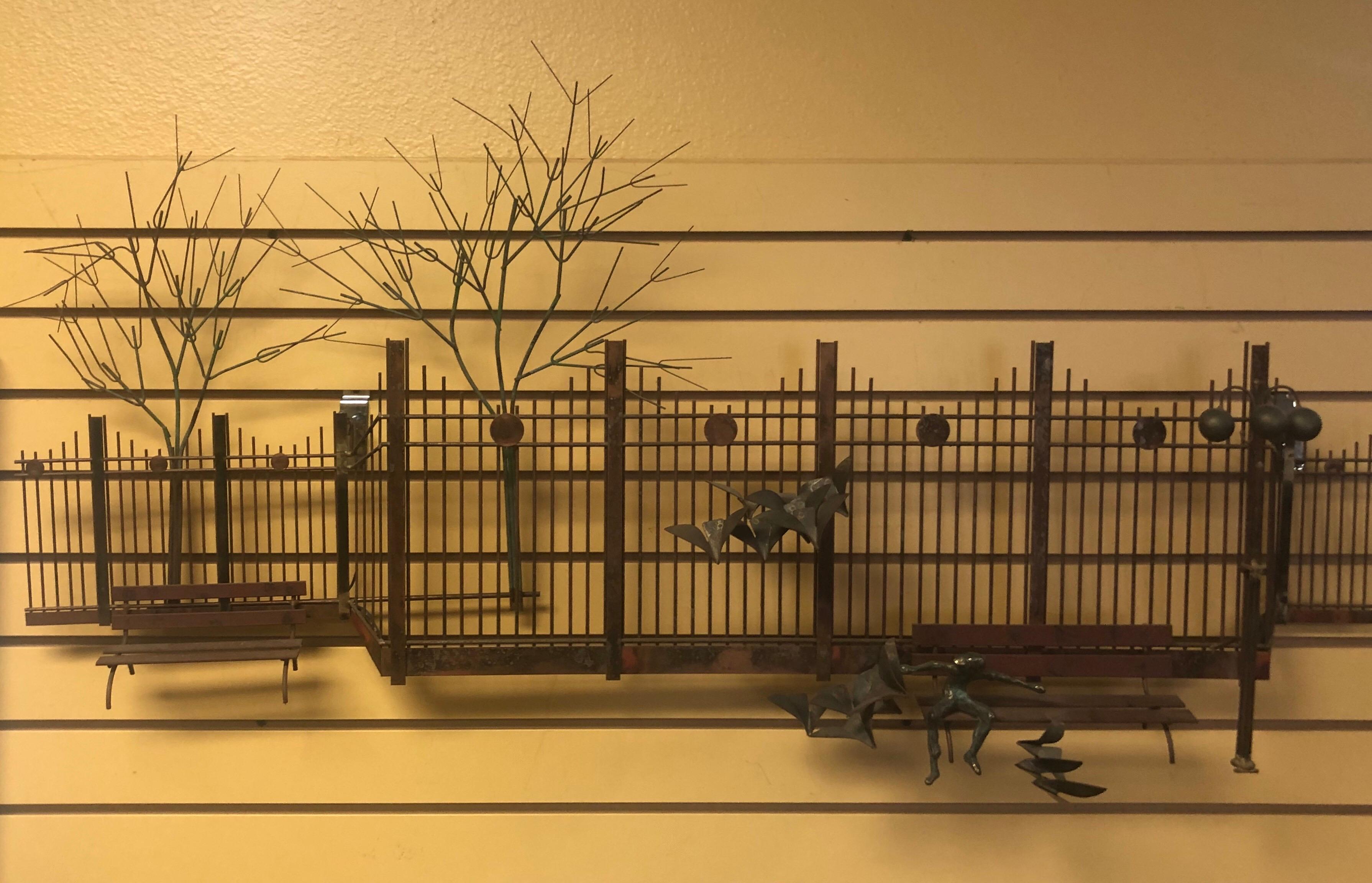 Unique park scene mixed metal wall sculpture by C. Jere for Artisan House, circa 1972. The piece, depicting a boy sitting on park bench with birds in flight, a fence, trees and lamp post, is in very good condition and has great color and