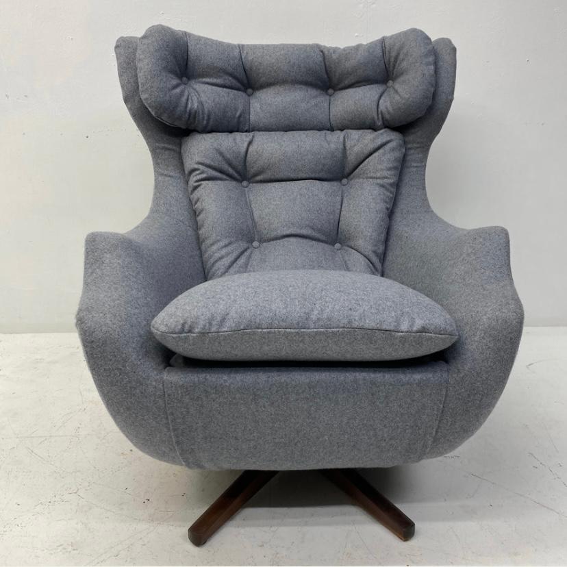A stunning British mid-century Parker Knoll Statesman lounge chair. The lounge chair sits on a teak swivel base & is completely professionally reupholstered in light grey British Abraham Moon wool fabric. The chair has fabric covered buttons to the