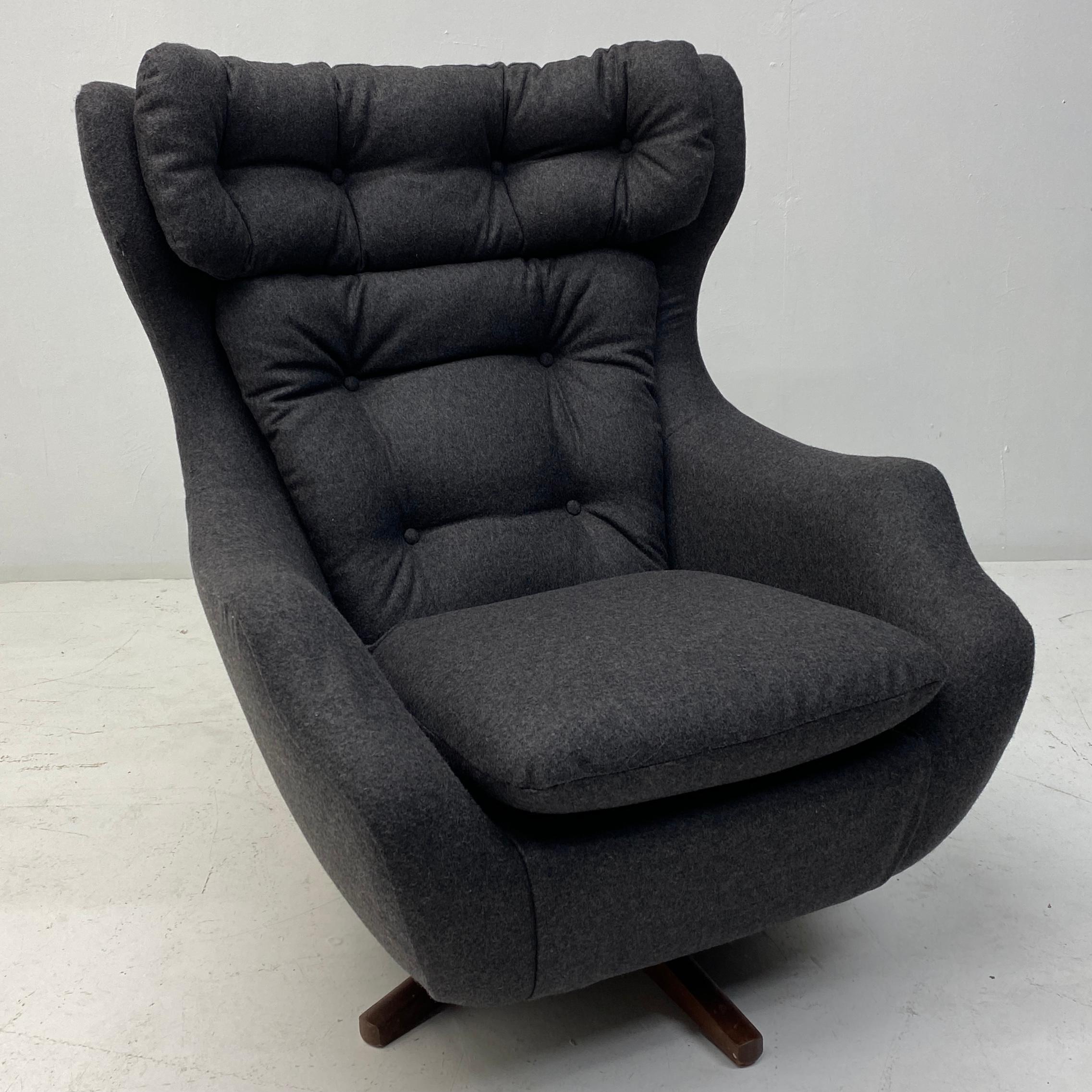 A stunning British midcentury Parker Knoll Statesman lounge chair. The lounge chair has a teak swivel base & has been completely professionally reupholstered in Taupe British Abraham Moon wool fabric. The chair has buttons to seat back & to the back