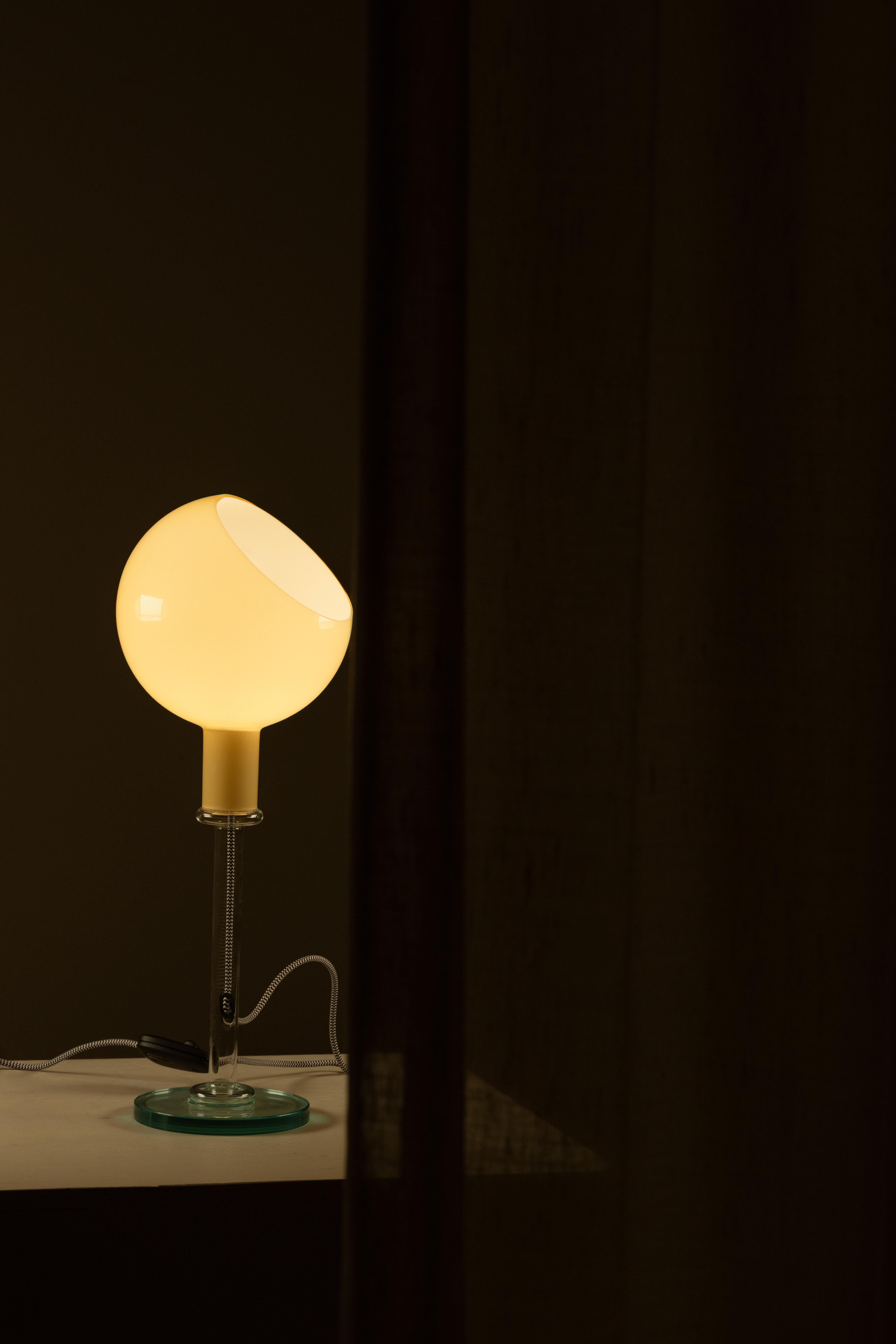 The “Parola” table lamp was born in 1980 as part of the artistic direction that Gae Aulenti took on at FontanaArte the previous year, a period marked by important projects, including the company’s new store in Via Monte Napoleone in Milan. In this