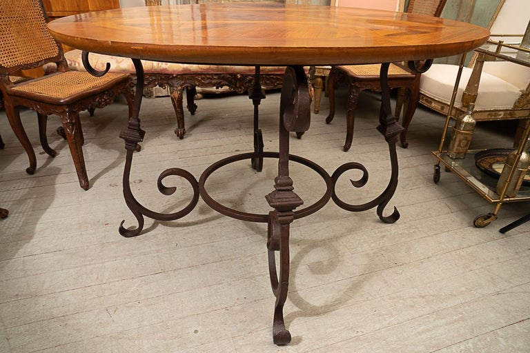 This is a hand made item using antique Parquet de Versailles flooring pieced together. The table comes in oval,rectangle and round. The rectangle tables have leaves which make them very versatile.The bases are made of wrought iron specific to each