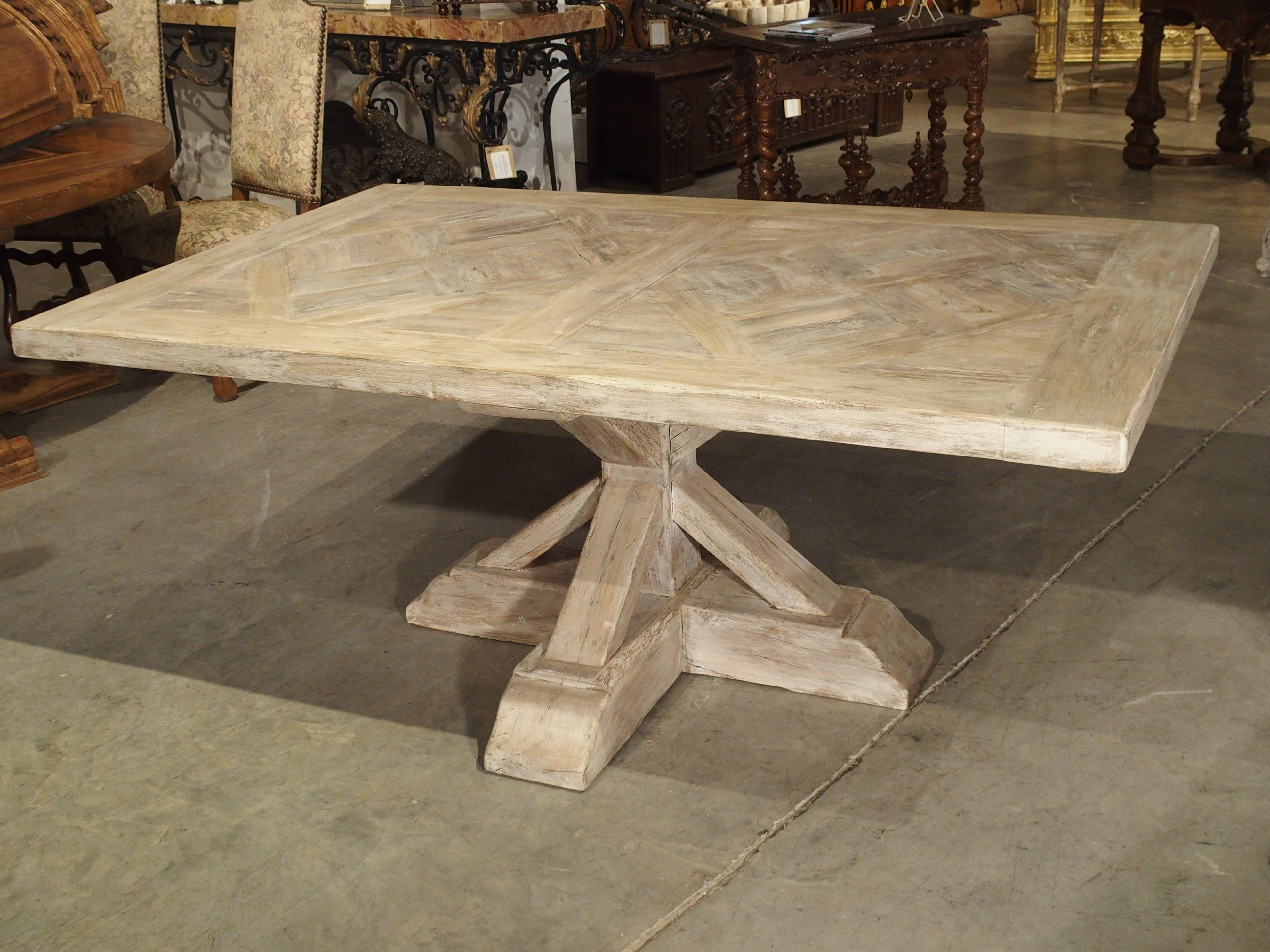 This whitewashed table was made near the Poitou region of western central France. It is constructed of thick salvaged boards of oak, and has a top that is made of two large parquet sections that are separated by a straight beam. Parquet describes