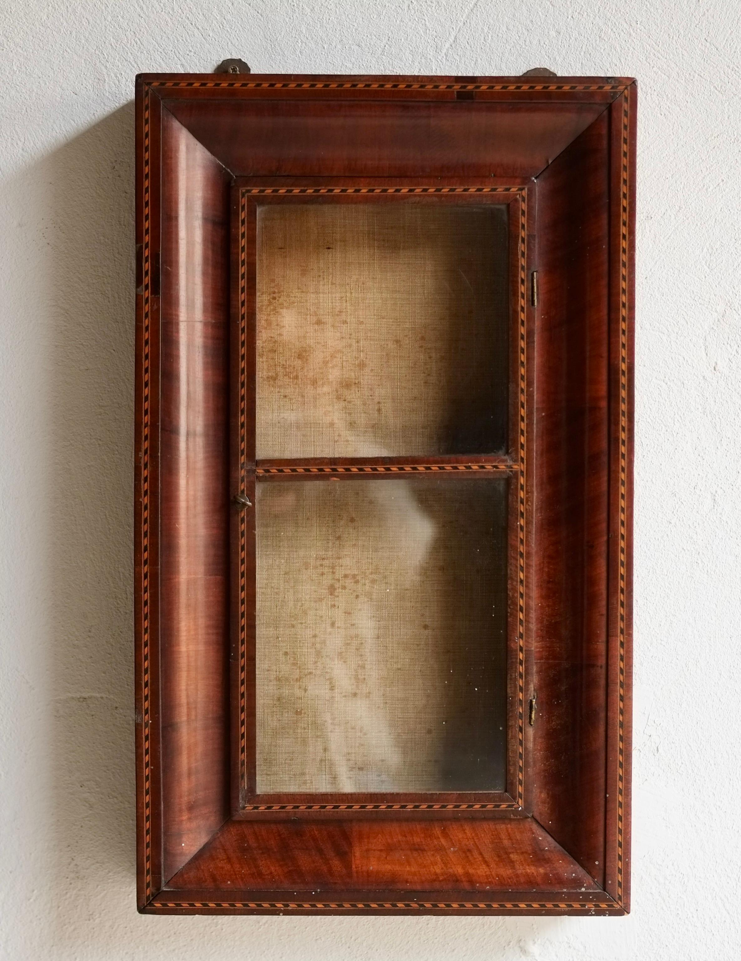 A 19th century French parquetry cabinet with it's original glass door and canvas back.