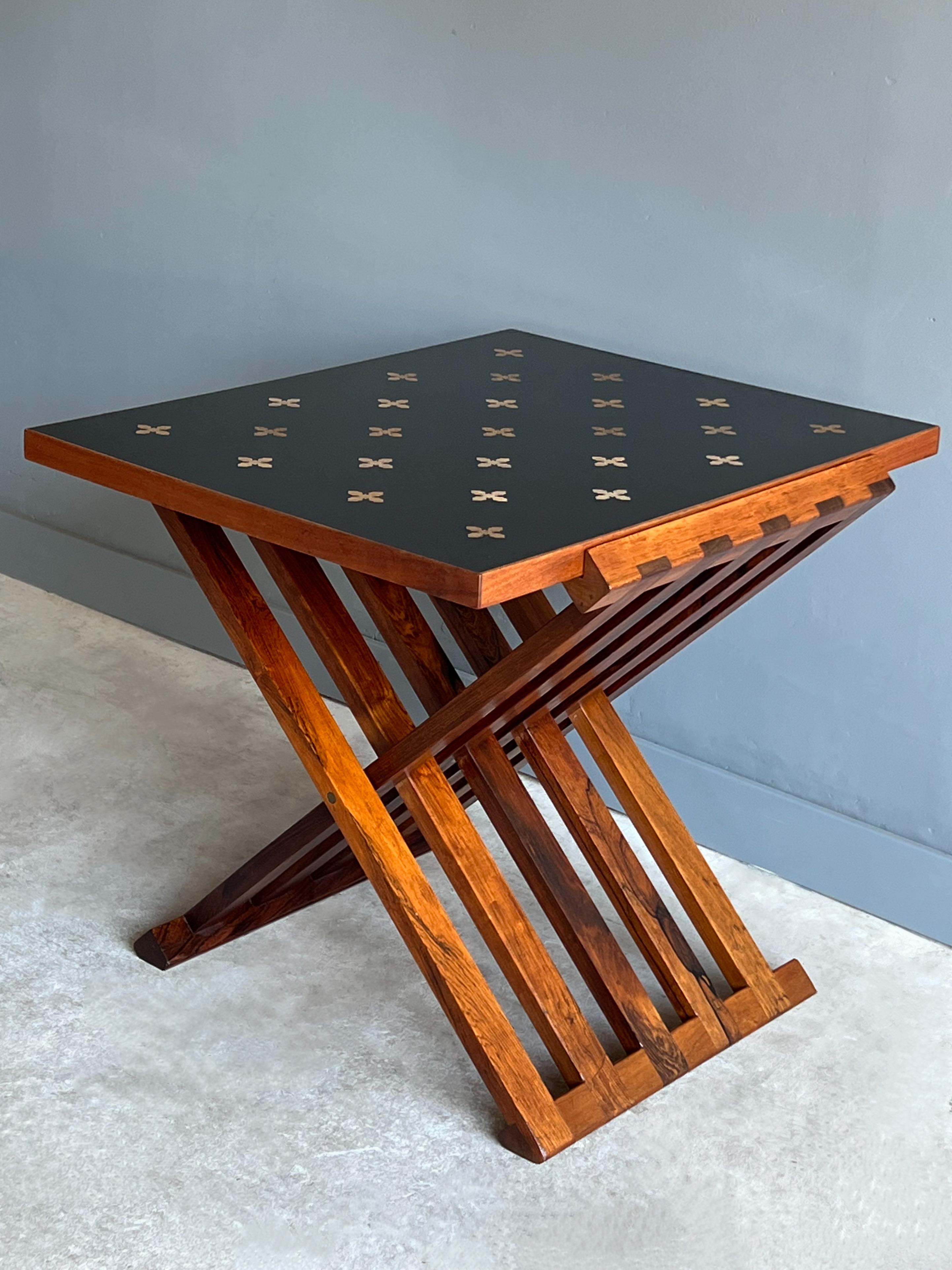 Amazing folding occasional or side table designed by Edward Wormley for Dunbar Furniture, Circa 1960s 

Model 5425E features a solid Brazilian Rosewood base that holds a walnut edged black laminate top with attractively spaced bleached mahogany