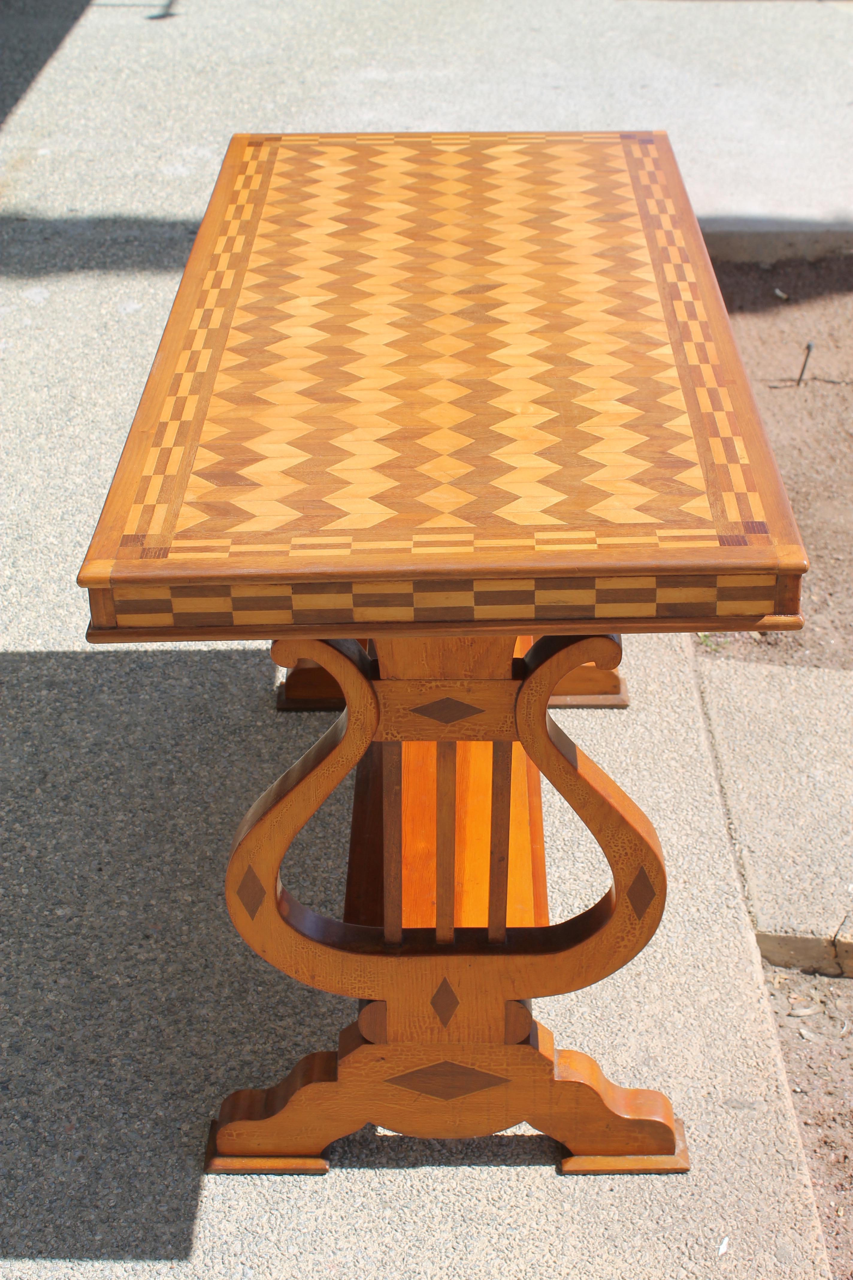 Parquetry table with Lyre supports on both ends. Lyre legs have an incredible patina. We lightly refinished the top of table. Table measures 43.25