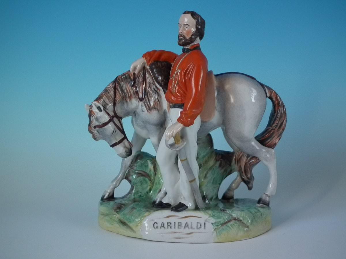 Parr Factory Staffordshire Pottery figure with a military theme which features Garibaldi and his horse, stood on a shaped base. The piece is titled, 'GARIBALDI'. Dull gilt embellishment. Decorated 'in the round' - decoration to front and reverse.