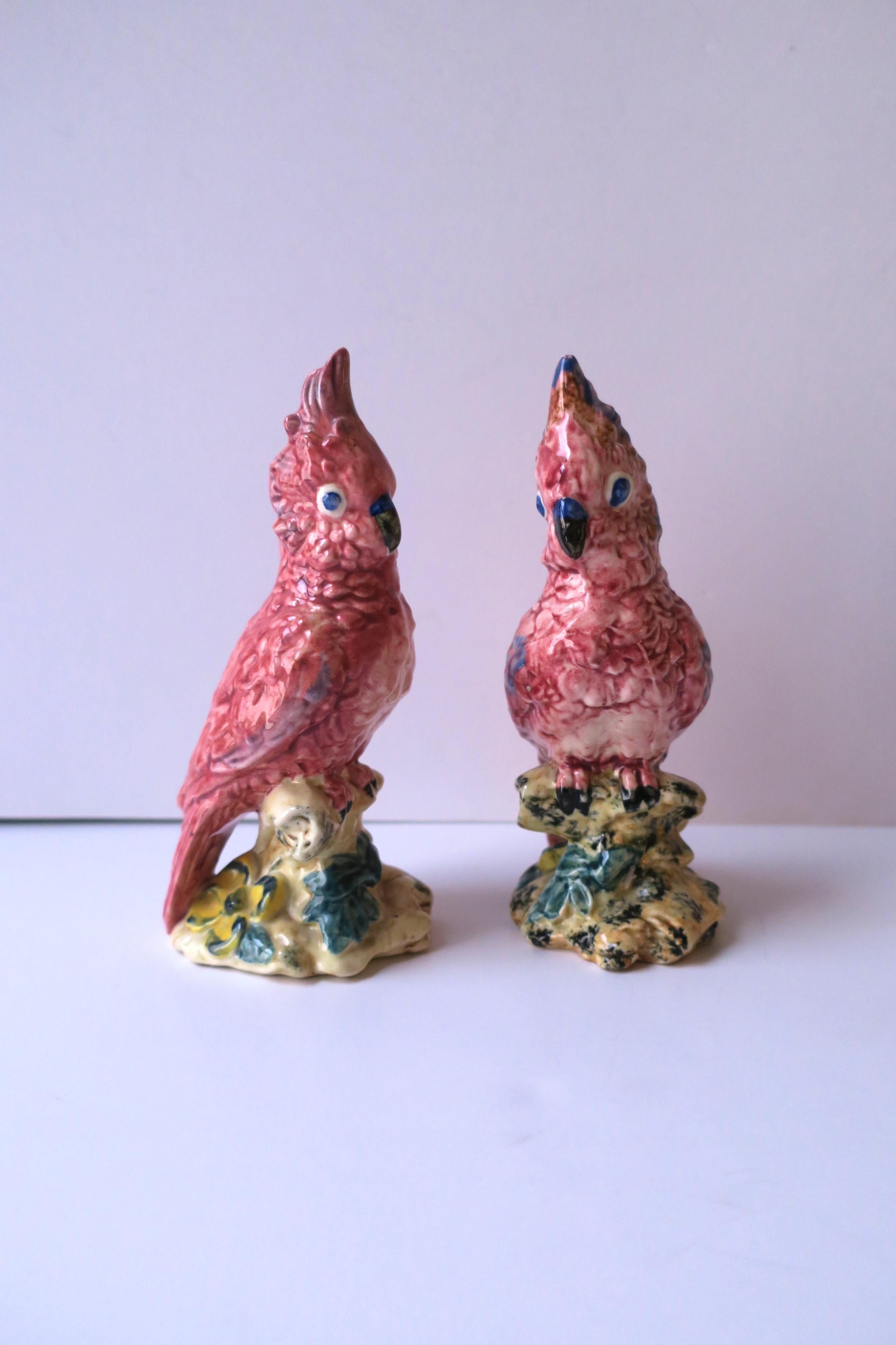 A beautiful pair of pink parrot birds, hand-painted, on branches with yellow hibiscus flower, circa mid-20th century, USA. A great set for a mantle, shelf, dining table, etc. Authentication marks include artist initials and markers' mark on bottom