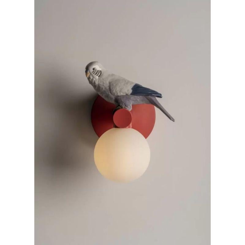Eine Wandleuchte aus der Kollektion Parrot Party, einem fröhlichen Beleuchtungskonzept, das auf dem Kontrast zwischen dem reinen geometrischen Design der funktionalen Objekte und der sehr realistischen Darstellung der niedlichen Vögel, die sie