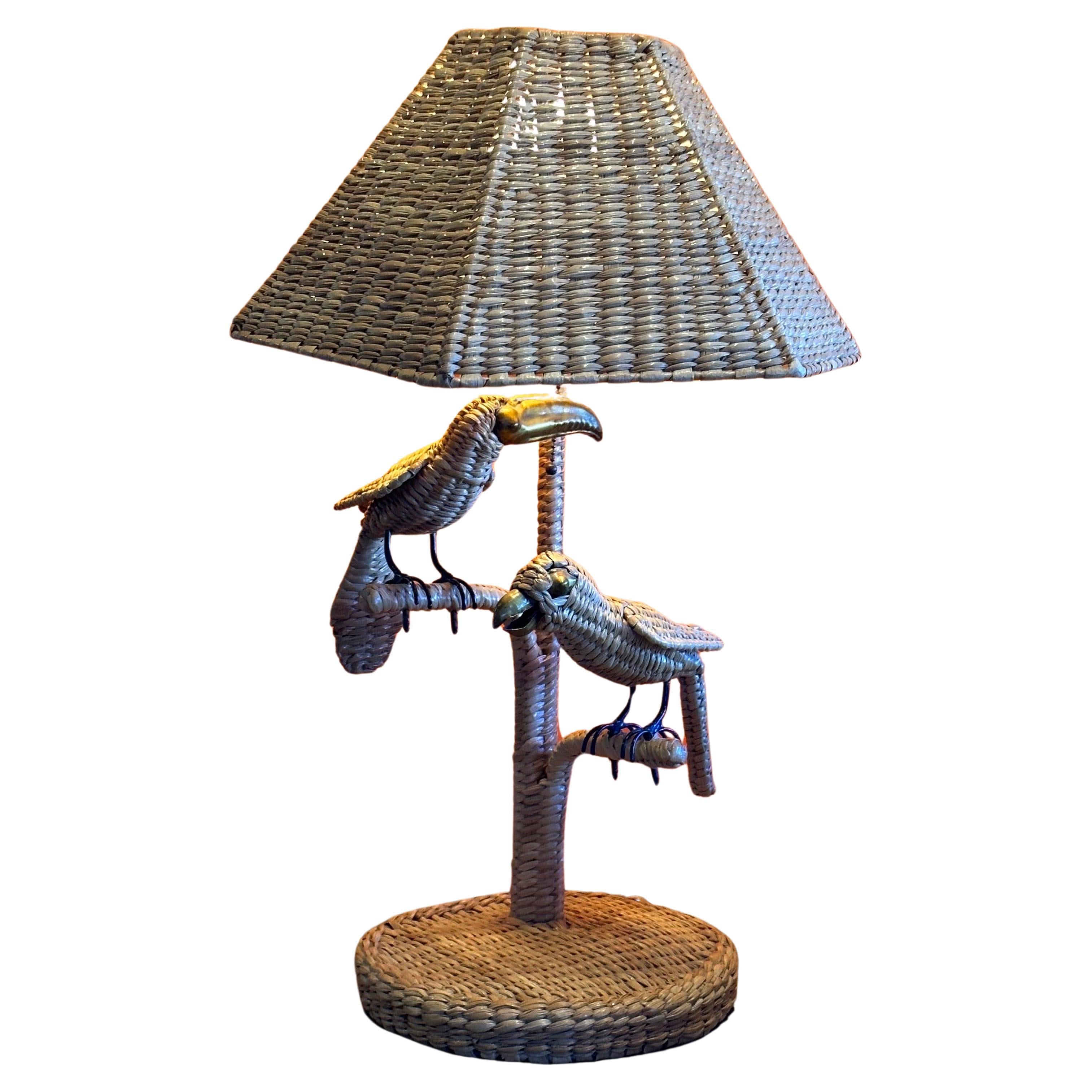A rare and fun parrot and toucan wicker table lamp by Mario Lopez Torres, circa 1970s. The lamp is in great vintage condition with two removable, handmade wicker birds with brass beaks and legs. The hexagonal shaped shade is 10.5