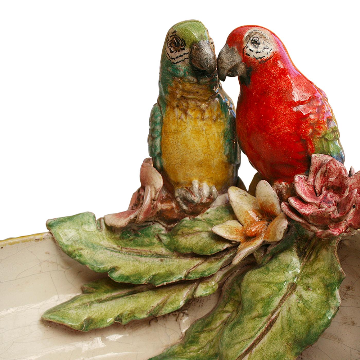 The mystery of nature in its secret perfection of shapes and colors inspired the lively personality of this ceramic centerpiece, part of the 2019 Primavera Collection. It is exquisitely adorned with incorporated figurines of parrots, perched onto