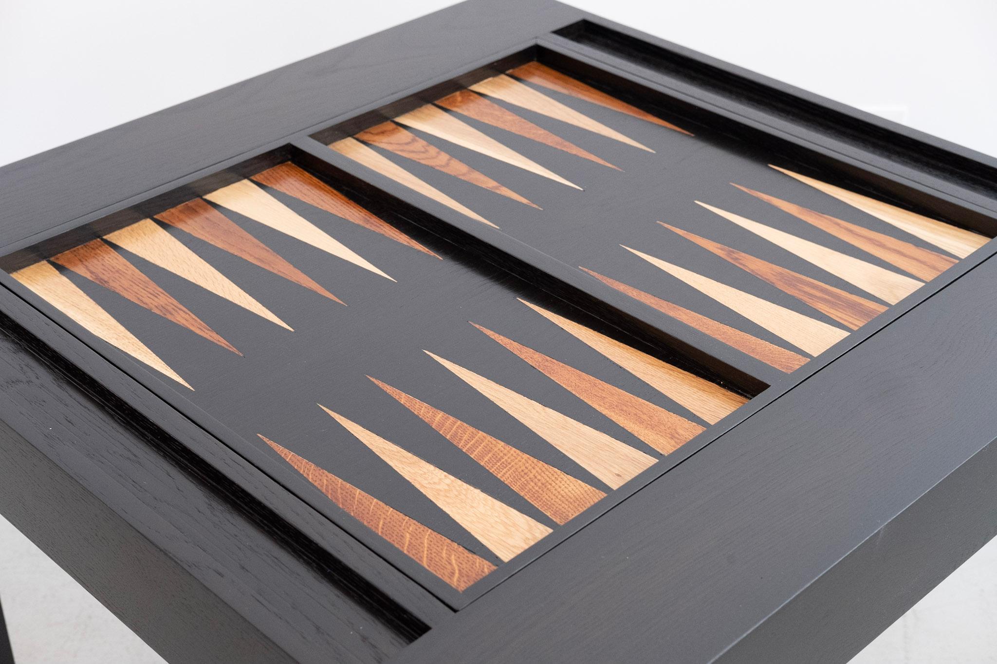 Parson's style backgammon table newly produced in walnut and refinished in ebony. The game board features hand inlaid mahogany and beech wood. Playing surface flips to reveal a solid walnut tabletop perfect for board or card games. Custom finishes