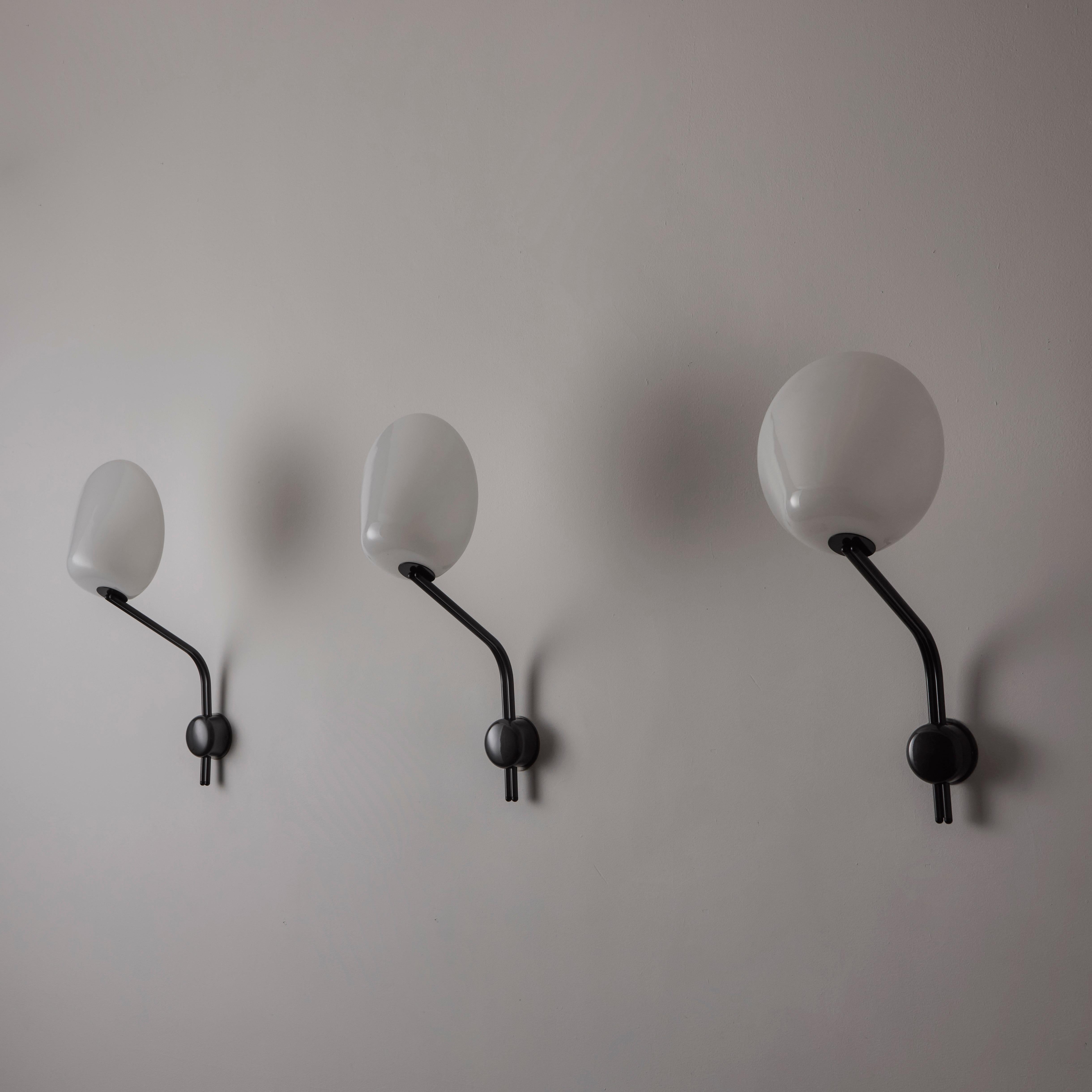 Apliques 'Parter' de Achille Castiglioni para FLOS. Diseñado y fabricado en Italia, hacia la década de 1970. Las carcasas de cristal blanco opalino se combinan con armaduras de acero galvanizado. Los apliques llevan una sola toma de tipo E27
