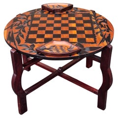 Mesa de juego de doble cara de madera tallada parcialmente ebonizada sobre soporte plegable