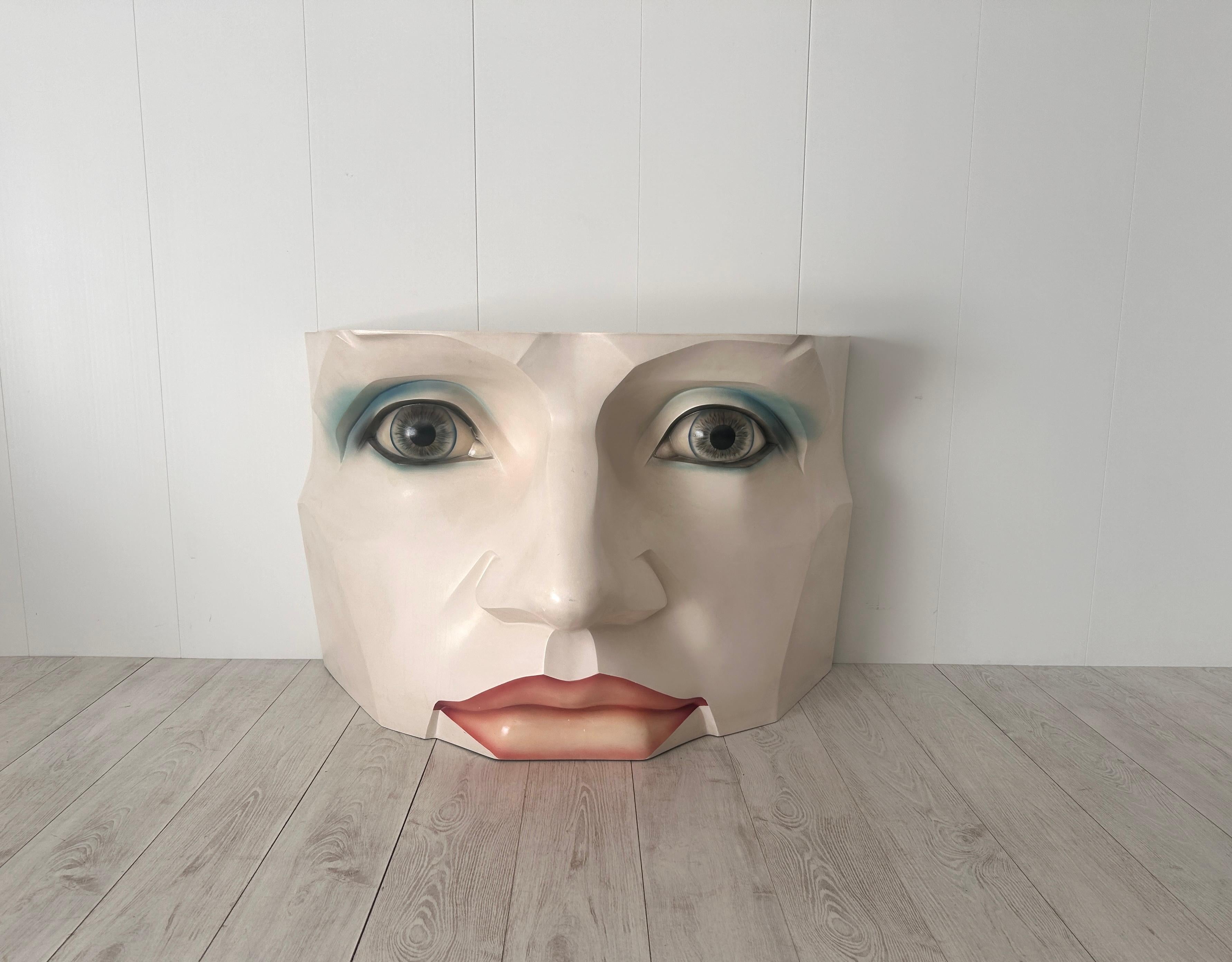 Particolare consolle - scultura a forma di viso di donna. 
Struttura in vetro resina, piano d'appoggio in vetro.

Anni '80, in ottimo stato di conservazione. Colori originali.