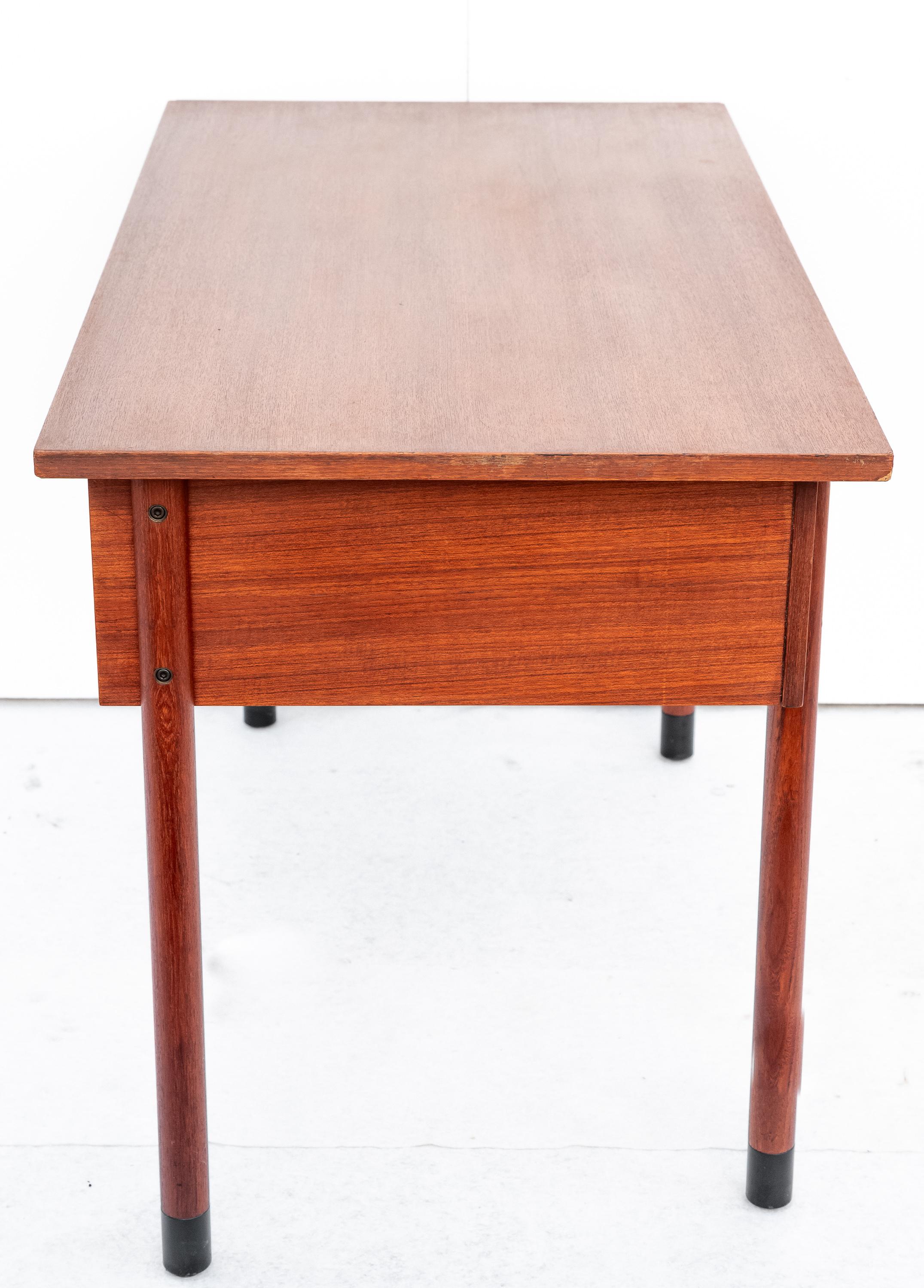 Particolare Scrittoio Nordico in teak, Anni '60. 
Straordinario Scrittoio di design nordico Originale Anni '60 in legno di teak di giuste dimensioni. La sua particolarità è il posizionamento delle gambe posteriori, che non sono simmetriche con