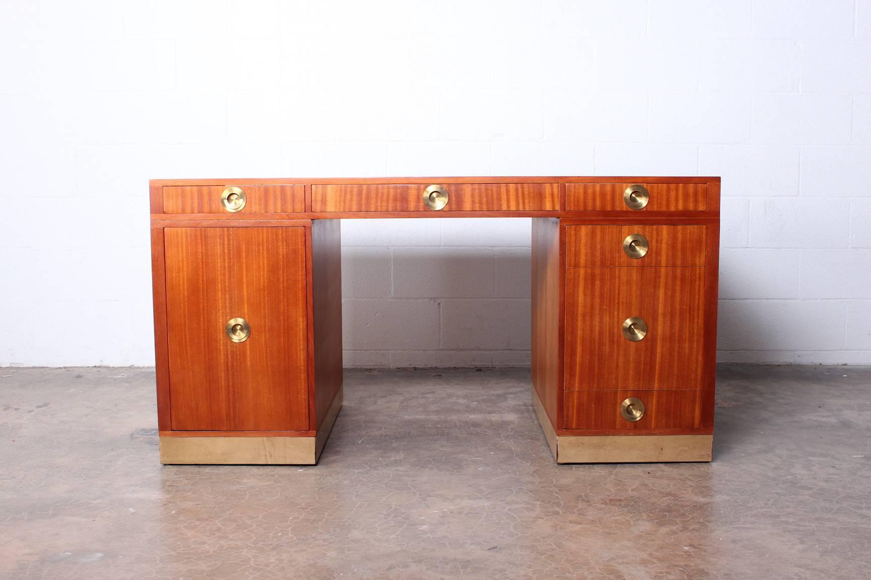 A mahogany partners desk with leather top and base and brass hardware. Designed by Edward Wormley for Dunbar.