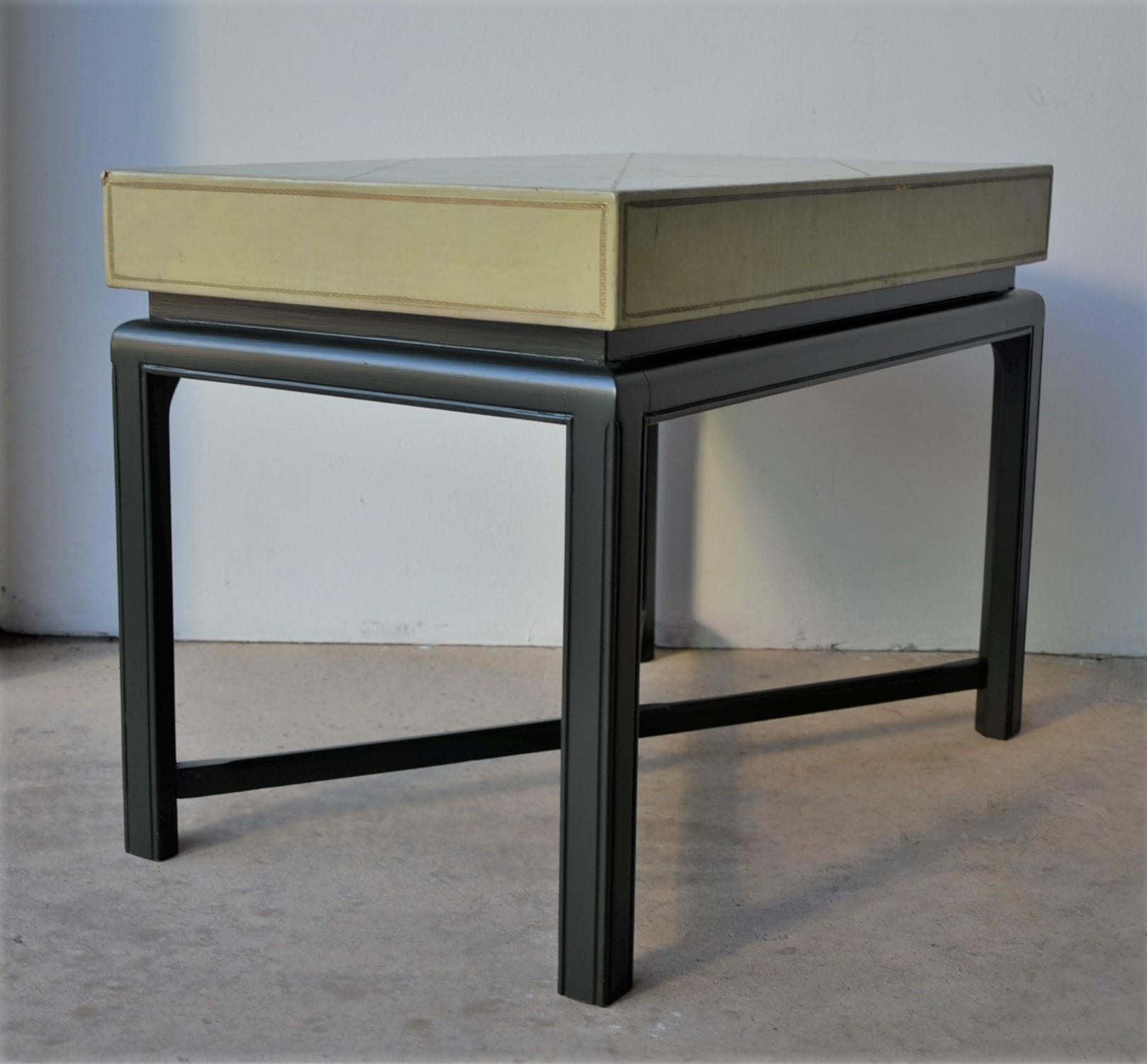 Offered is a Mid-Century Modern small and elegant side table by Tommi Parzinger, light green with gold accents tooled leather wrapping of a rectangular box-form top poised atop a newly lacquered dark green wood base with X-form stretcher. While