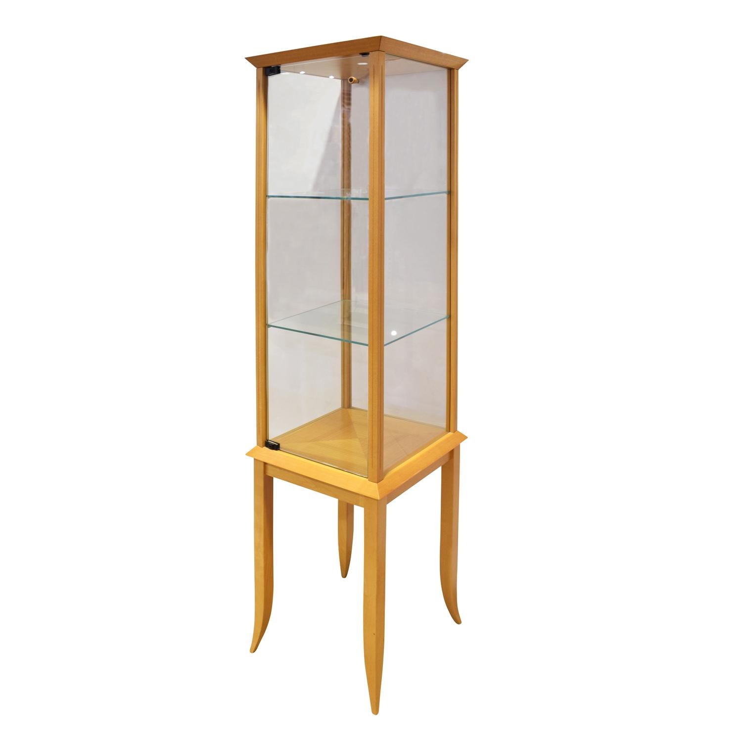 Petit display cabinet/vetrine in light walnut and glass with tapering legs by Tommi Parzinger for Parzinger Originals, American 1960s. This came from the home of a collector who was friends with Parzinger. It is a rare Parzinger gem.