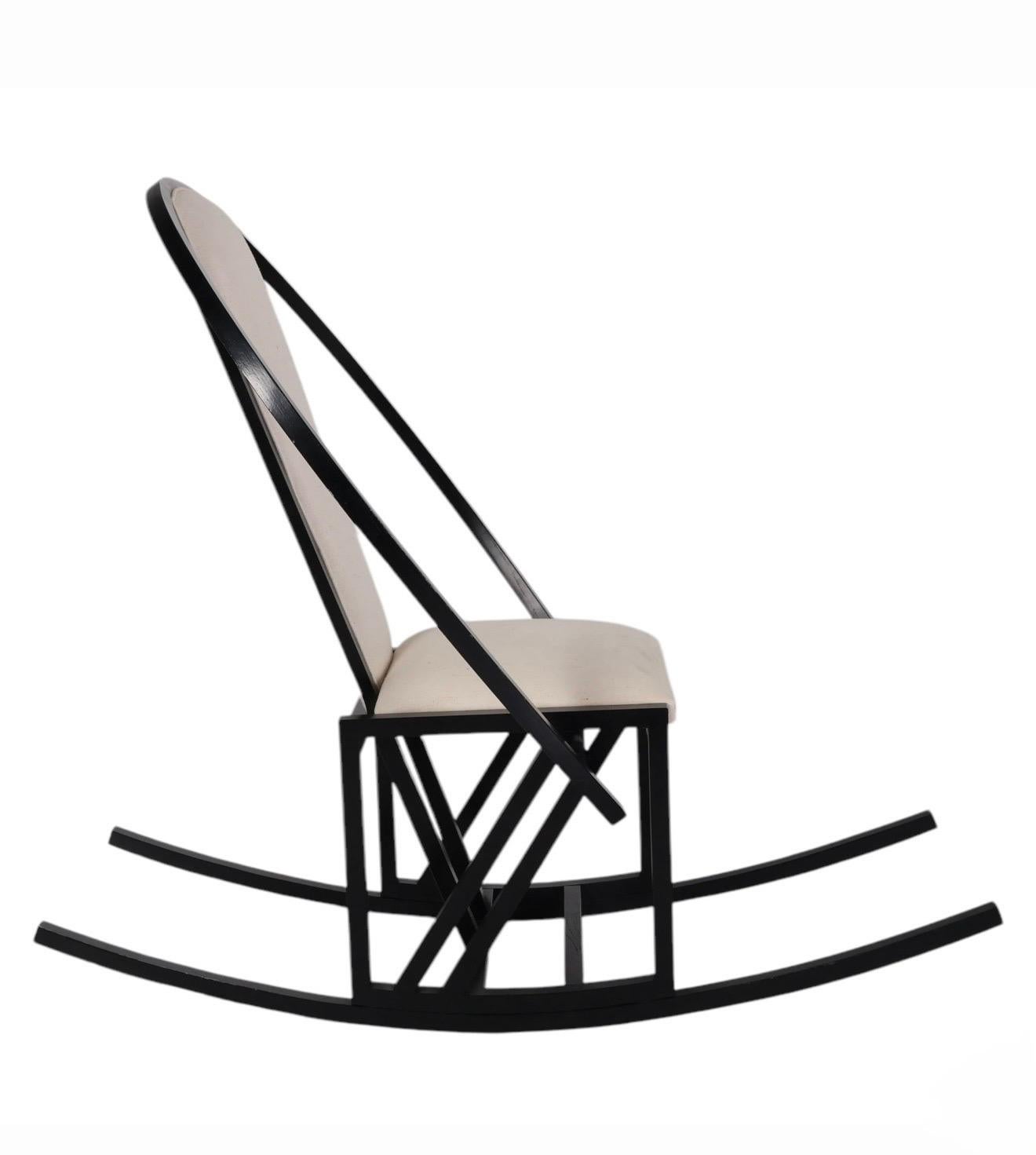 Pascal Mourgue (Francia, 1943-2014)
Model No. 
Sedia a dondolo, fine del XX secolo. 
Una struttura in legno annerito con uno schienale ellittico scultoreo e una base a dondolo, abbinata a un cuscino di seduta imbottito color avorio o bianco