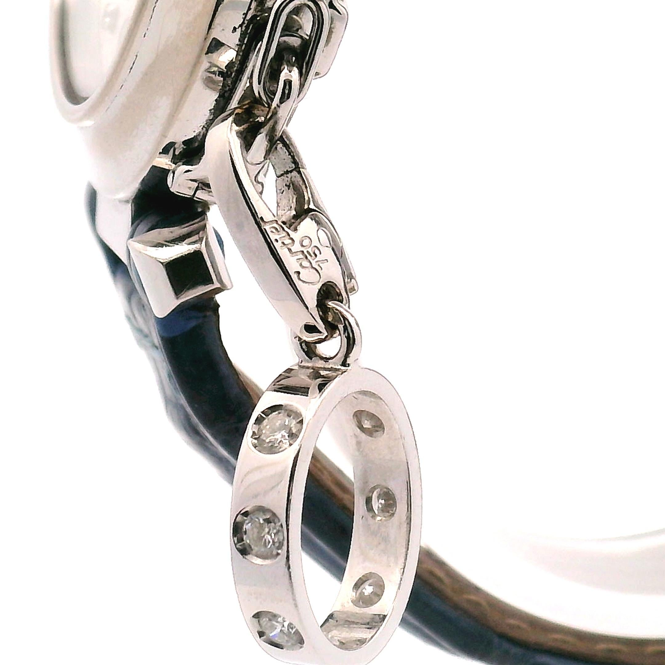 32mm Pasha de Cartier 18k white gold with a diamond enhanced dial. The model number is 2398 
Comes with a Cartier 18k white gold diamond enhanced ring charm.
The Cartier Paris blue leather strap has the original 18k white gold buckle. 
Automatic