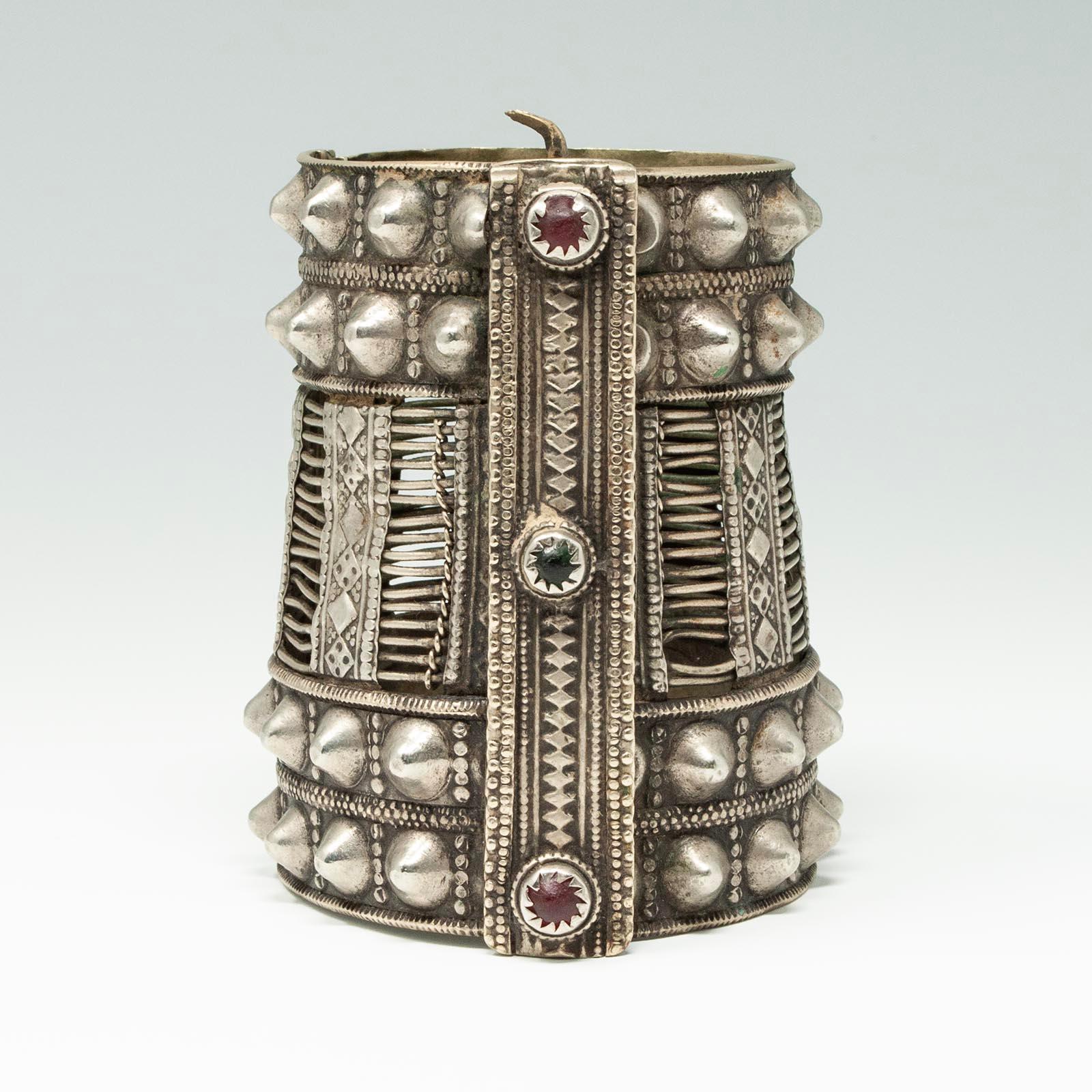 Bracciale a cerniera con spillo in argento Pashtun

Grande bracciale a spillo in lega d'argento del popolo Mangal Pashtun, al confine tra Afghanistan e Pakistan. Il perno di chiusura è nascosto dietro una fascia centrale verticale decorata con vetri