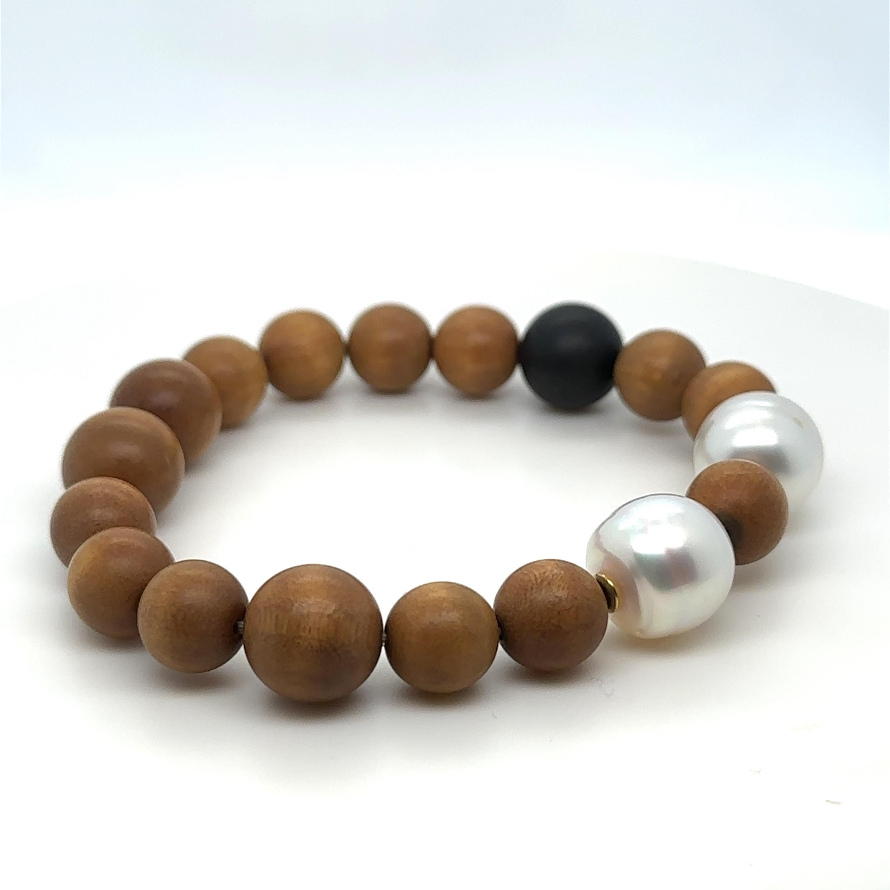 Ein Paspaley Onyx-Armband mit einem erdigen Perlen-Design. Eine Kombination aus zwei handverlesenen Perlen und Onyx mit hellem einheimischem Sandelholz, die die raue Schönheit der KIMBERLY-Küste einfängt. Mit 2 x 12 mm runden australischen