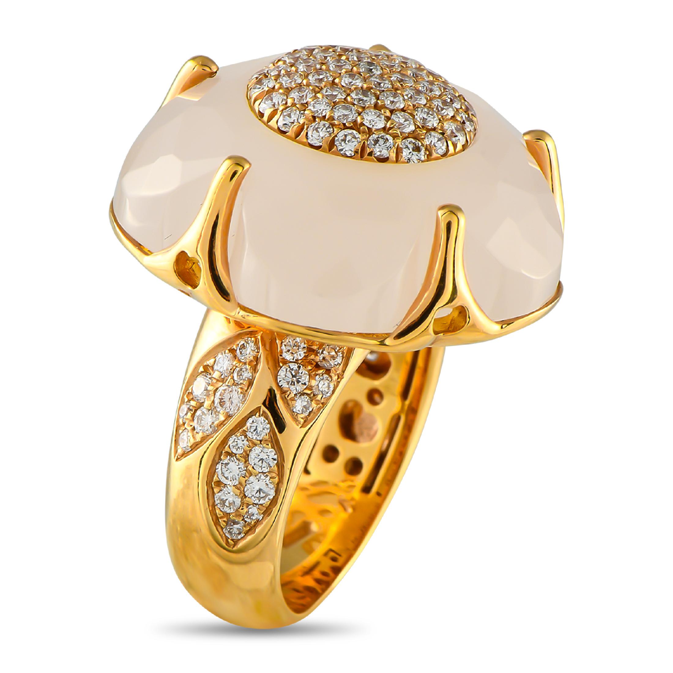 Ein Ring, inspiriert von weiblicher Stärke und Schönheit. Er besteht aus einem dicken Gelbgoldband mit Schultern, die mit zierlichen runden Diamanten auf drei blattförmigen Büscheln besetzt sind. Im Rampenlicht steht ein gewölbter Rosenquarz in