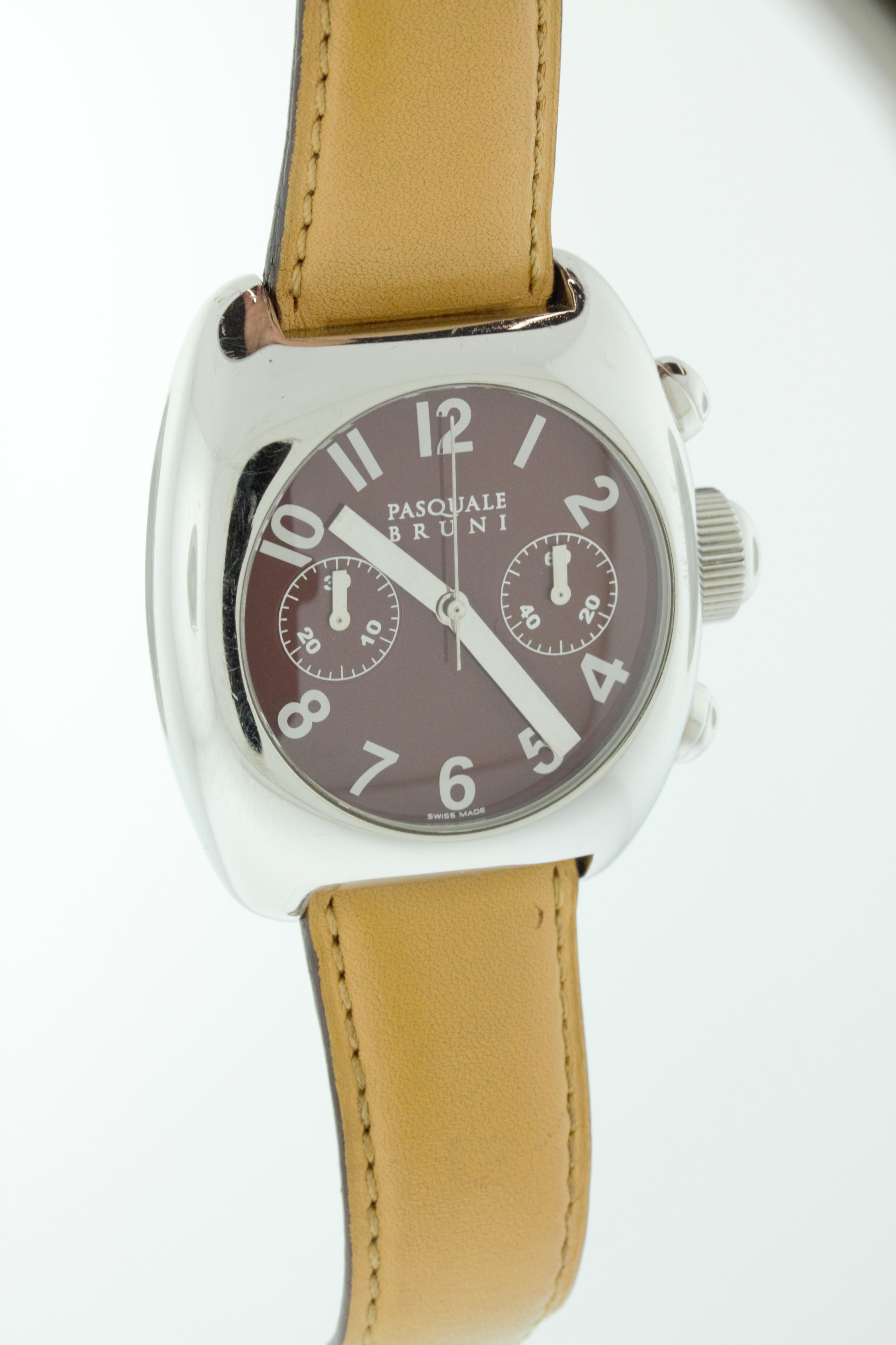 Cette montre en acier inoxydable présente un cadran brun et un bracelet en cuir brun. Fabriqué en Suisse par Pasquale Bruni. 
La face avant de l'étui est en très bon état avec quelques rayures mineures. Le bracelet en cuir et le dos de l'étui
