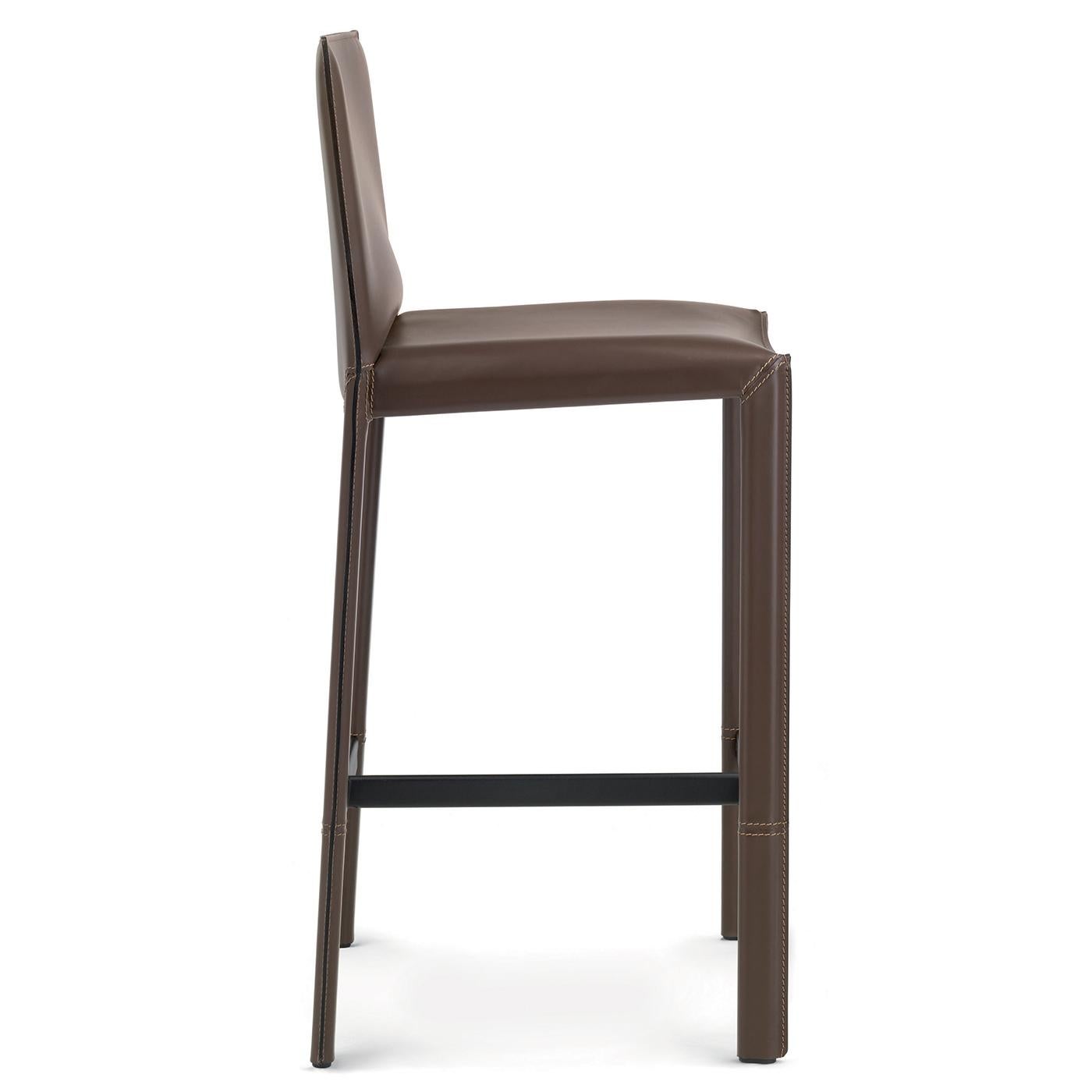 This sturdy counter stool features a tubular steel frame completely covered in terra-colored leather and a black, embossed footrest. Black technical fabric covers the metal seat pan. Its barely-there profile is made up of sleek geometric lines at