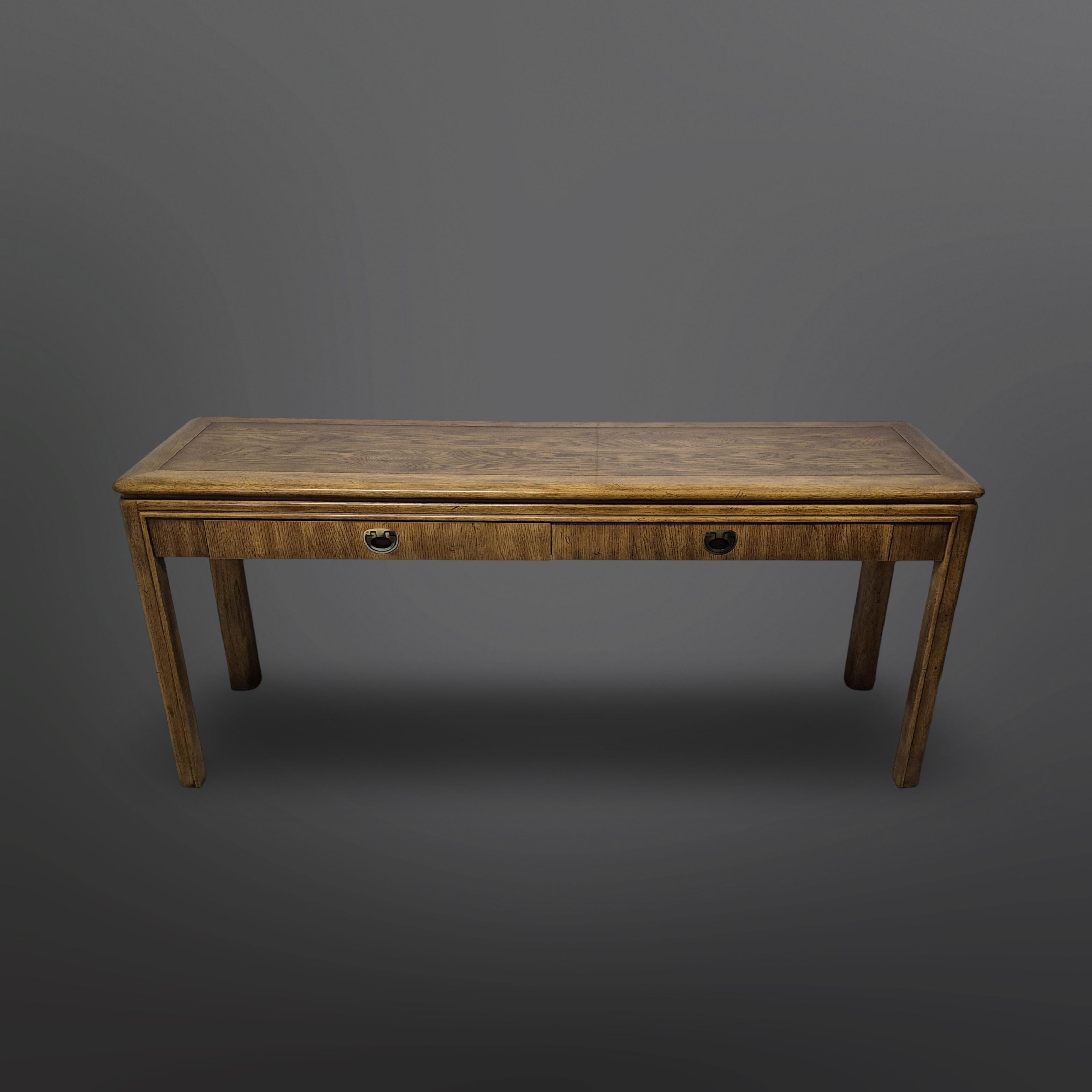 Beistelltisch im Campaigner-Stil mit zwei großen Schubladen. Hergestellt aus Holz mit Eichenfurnier. Die Schubladen haben versenkte Scharniergriffe.
Hergestellt von Drexel im Jahr 1987.
Dieser Beistelltisch ist Teil der Serie 