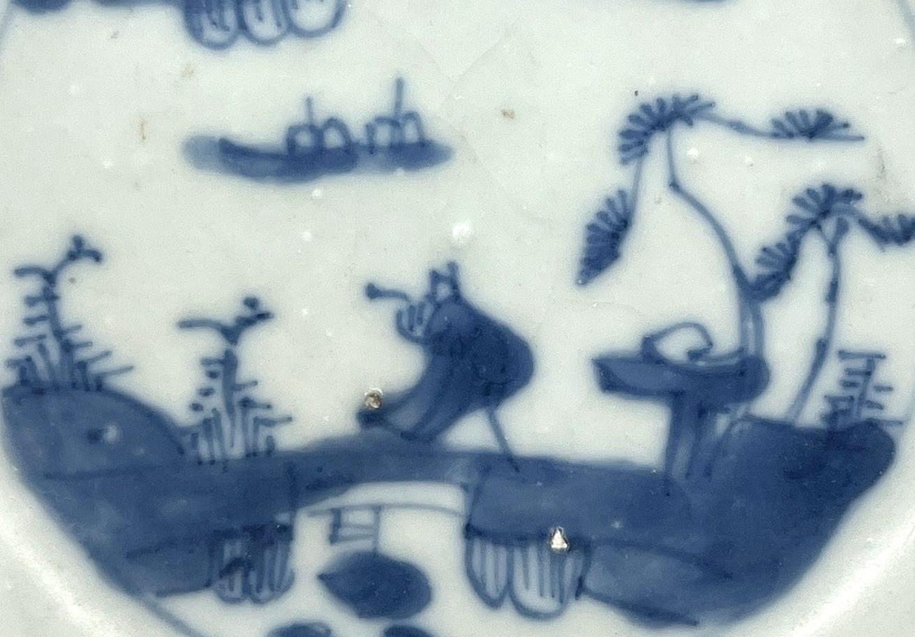 With a medallion of two boats sailing together, passing an island on which a solitary figure stands by or on a bridge, the rim with a narrow heringbone pattern, the reverse glazed cafe-au-lait

Period : Qing Dynasty, Yongzheng Period
Production Date