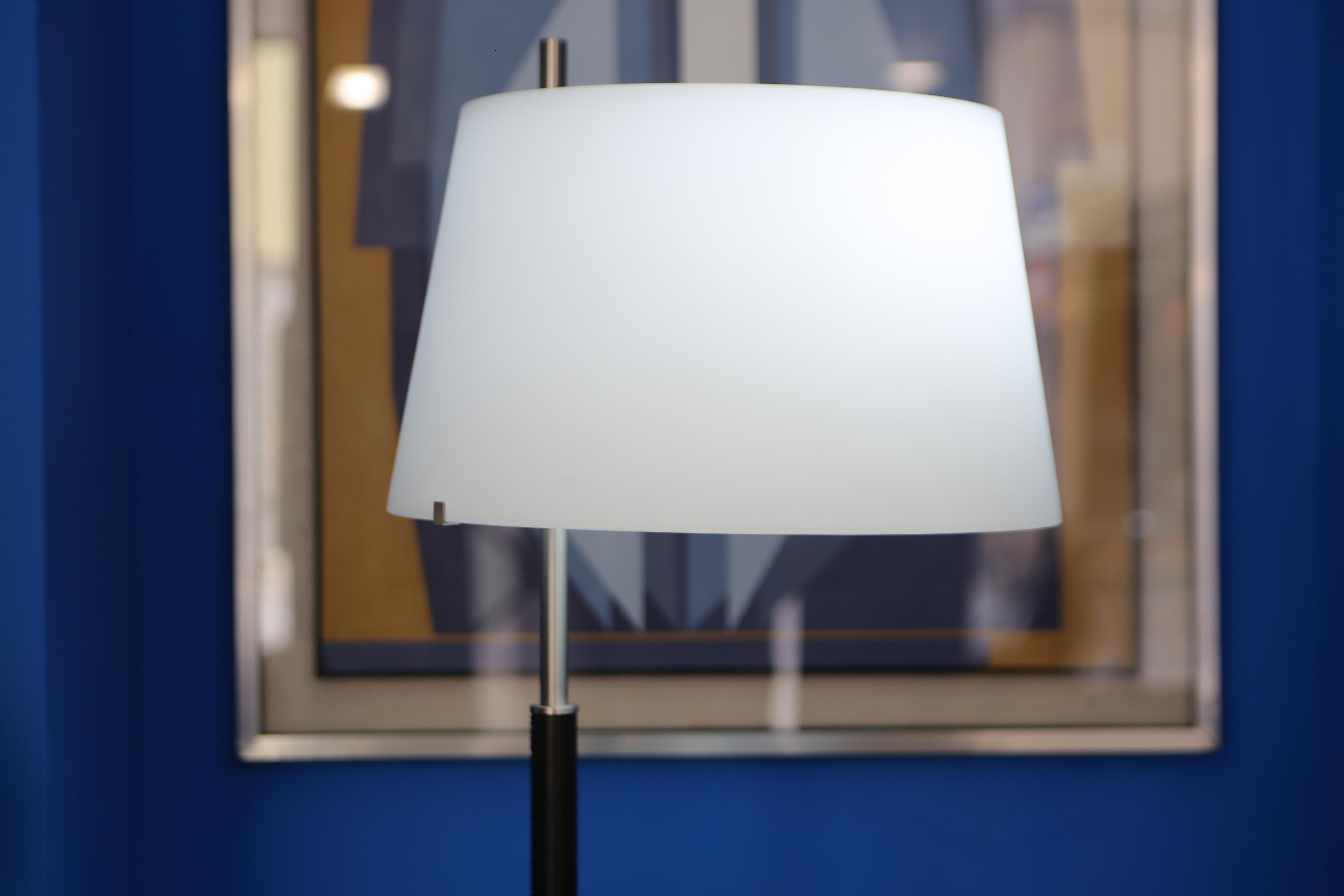 La lampe de table Fontana Arte Passion, conçue par le Studio Beretta, offre une interprétation sobre de la tradition de l'éclairage design, en combinant des lignes essentielles et des matériaux de choix. Le profil épuré présente un cadre en métal