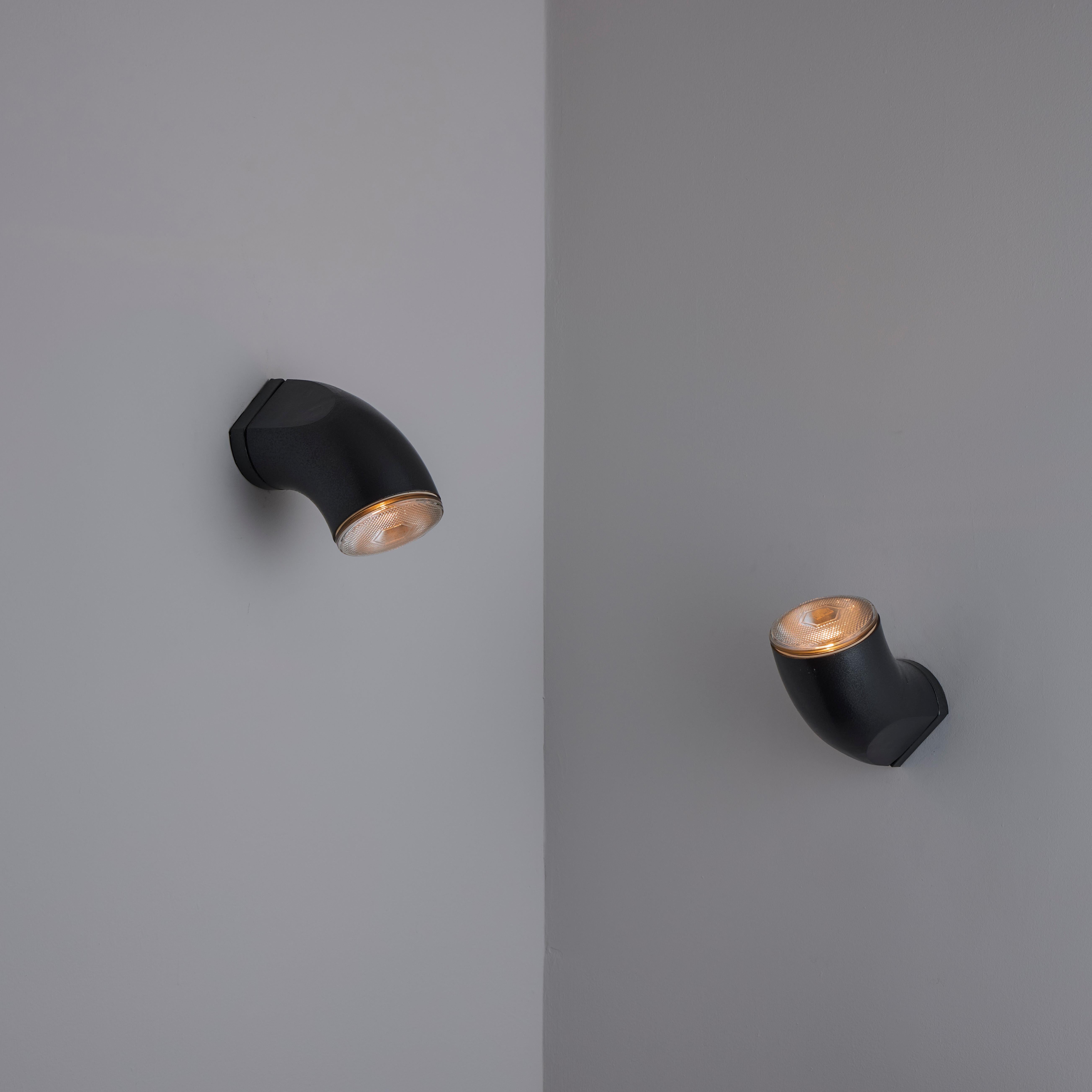 Lampada da parete per esterni 'Passo' di Artemide. Progettato e prodotto in Italia, intorno agli anni '1980. Corpo curvo in alluminio fuso. Ogni lampada è dotata di un singolo attacco a base media. Si consiglia di utilizzare una lampada PAR38 da
