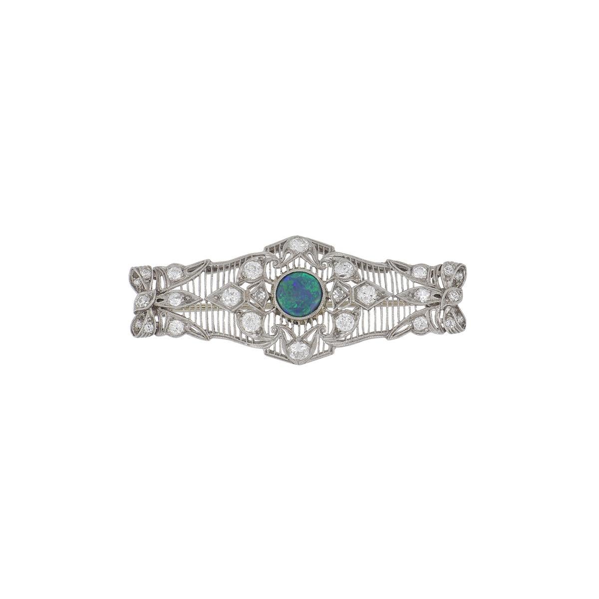 Art Deco filigree openwork rectangular shaped pin composed of platinum set with round diamonds, featuring a central round black opal. The pin contains 1.37 total carats of diamonds, G-I color and VS1-I1 clarity.  Circa 1920.