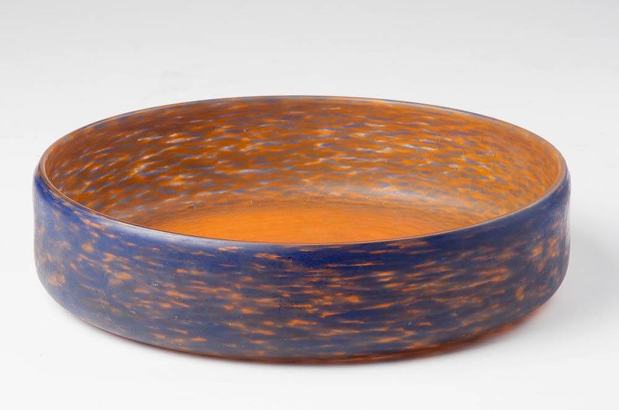 Grande coupe à fruits en pâte de verre, dans une combinaison de couleurs typiques de l'art déco, bleu et orange. Couleurs très vives. La surface du plat est lisse, elle n'est pas brillante.
Sur le côté, il est signé par le fabricant, mais c'est un