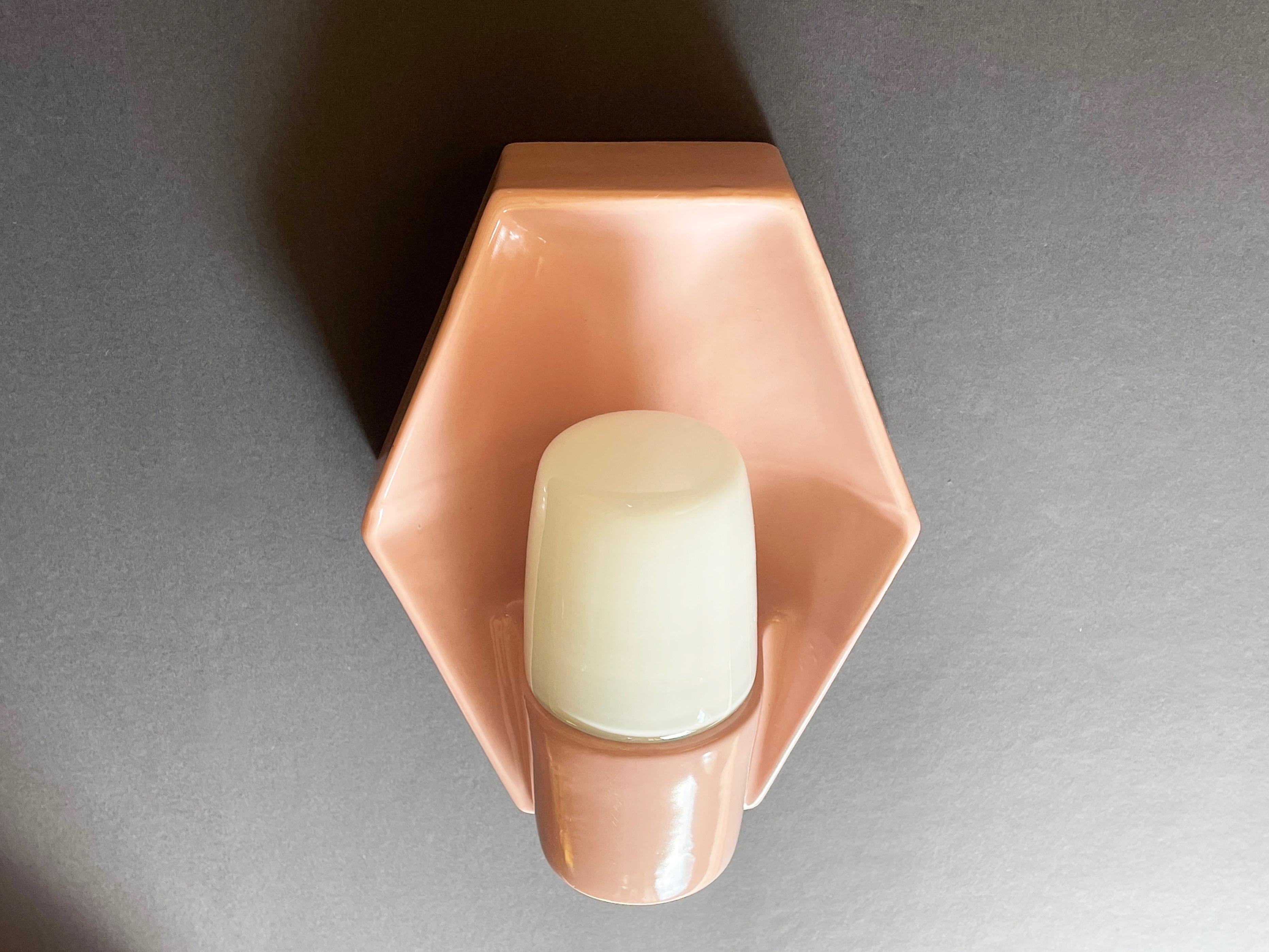 Una rarissima applique esagonale di colore rosa pastello in ceramica e vetro opalino.
Questo pezzo insolito risale alla metà degli anni '50 ed è stato realizzato da 
Lyskaer Belysning, Danimarca, dopo le lampade Bauhaus di Wilhelm
