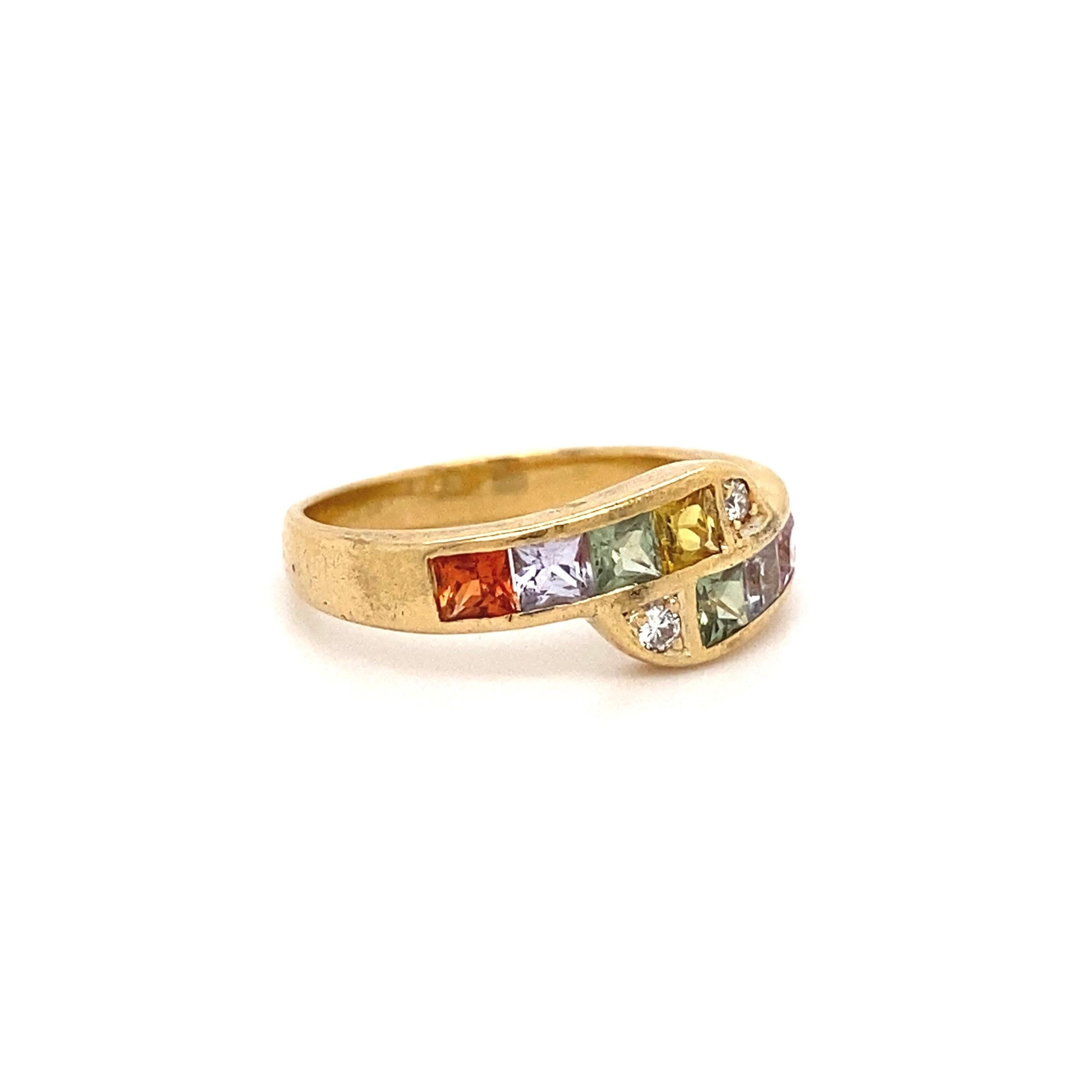 Simply Beautiful! Crossover Pastel Rainbow Sapphire and Diamond Gold Bypass Band Ring. Hand set with 8 square cut Pastel Sapphires weighing approx. 1.20tcw and 2 Round Brilliant Diamonds, approx. 0.04tcw. Dimensions: 0.74” w x 0.28”h x 0.76” d. This