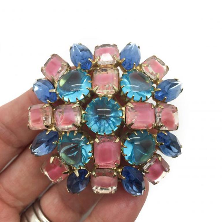A striking 1950s Vintage Crystal Pastel Glass Brooch. Featuring navette, round and emerald cut pink givre crystals in claw settings in gold tone metal mounts. This pastel glass brooch measures approx. 5.5cm wide and is in very good vintage