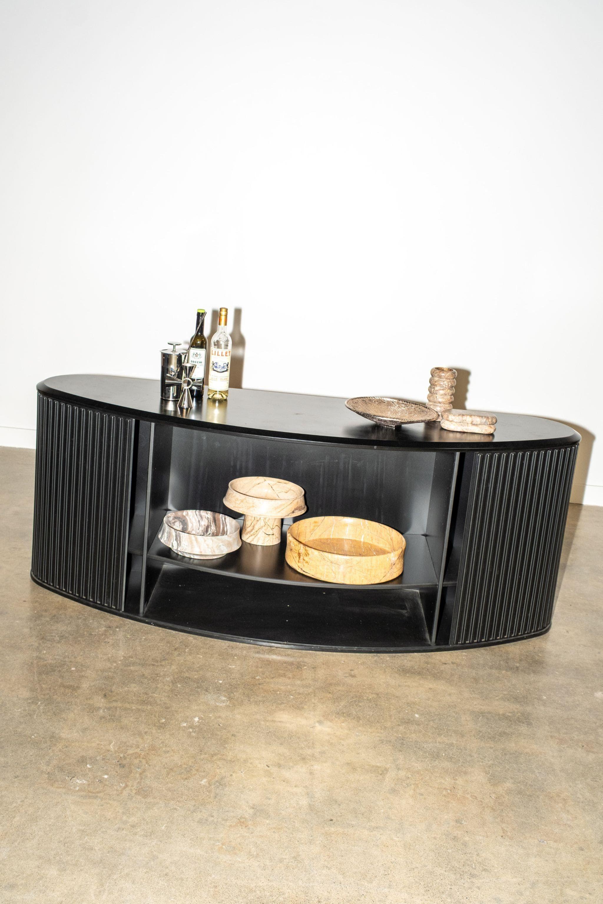 L'A'dammer est un exemple remarquable de meuble conçu comme un objet de design artistique. Sa caractéristique est le volet roulant nervuré, qui peut coulisser sans effort et être dissimulé à l'arrière du meuble. La texture nervurée sert de poignée