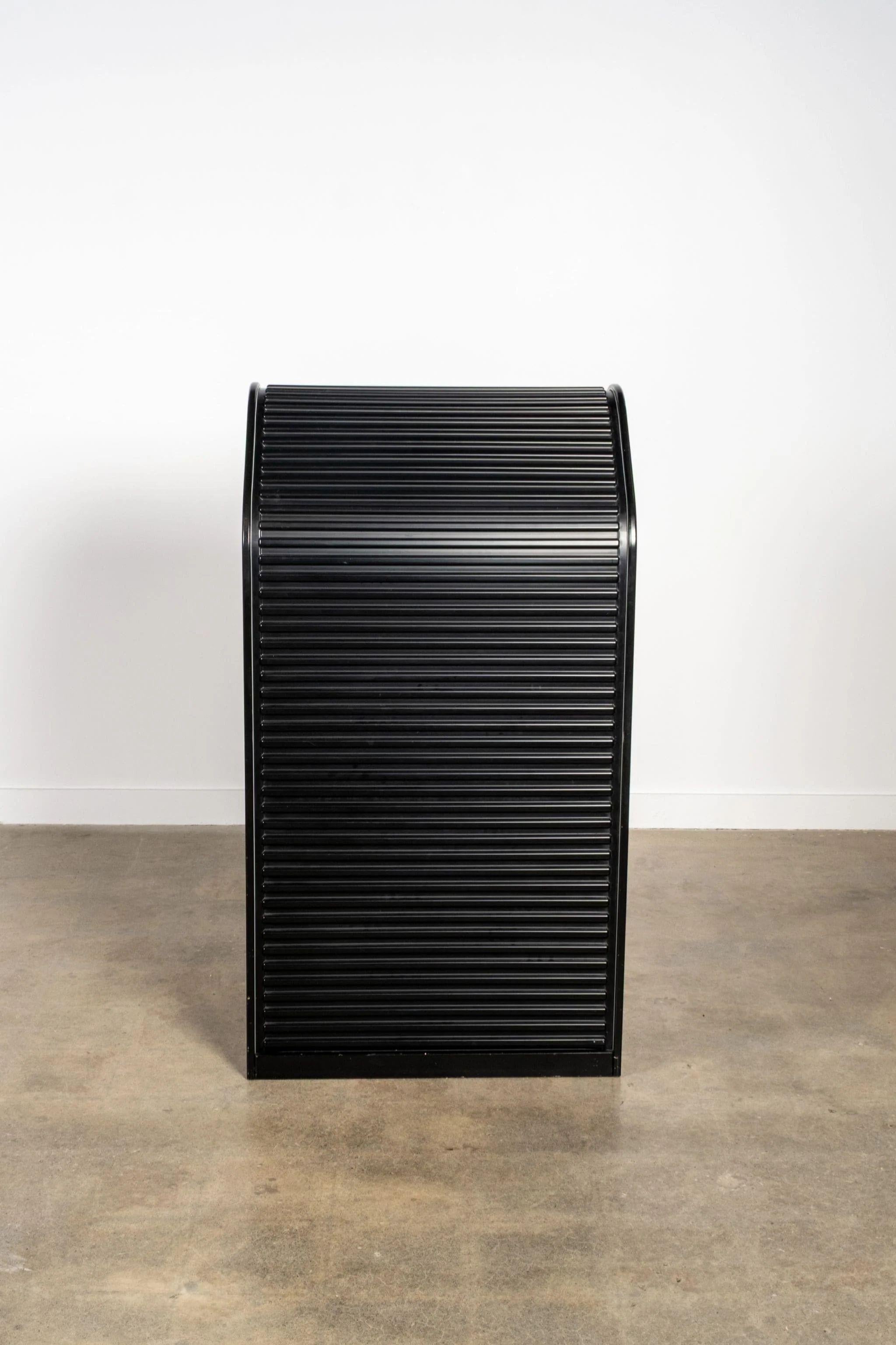 Designed in the 1980s by Aldo van den Nieuwelaar for UMS Pastoe, the Amsterdammer bookcase brings rhythm and refinement to everyday storage. Its signature slatted tambour doors, rounded edges, and modular construction reflect the designer’s