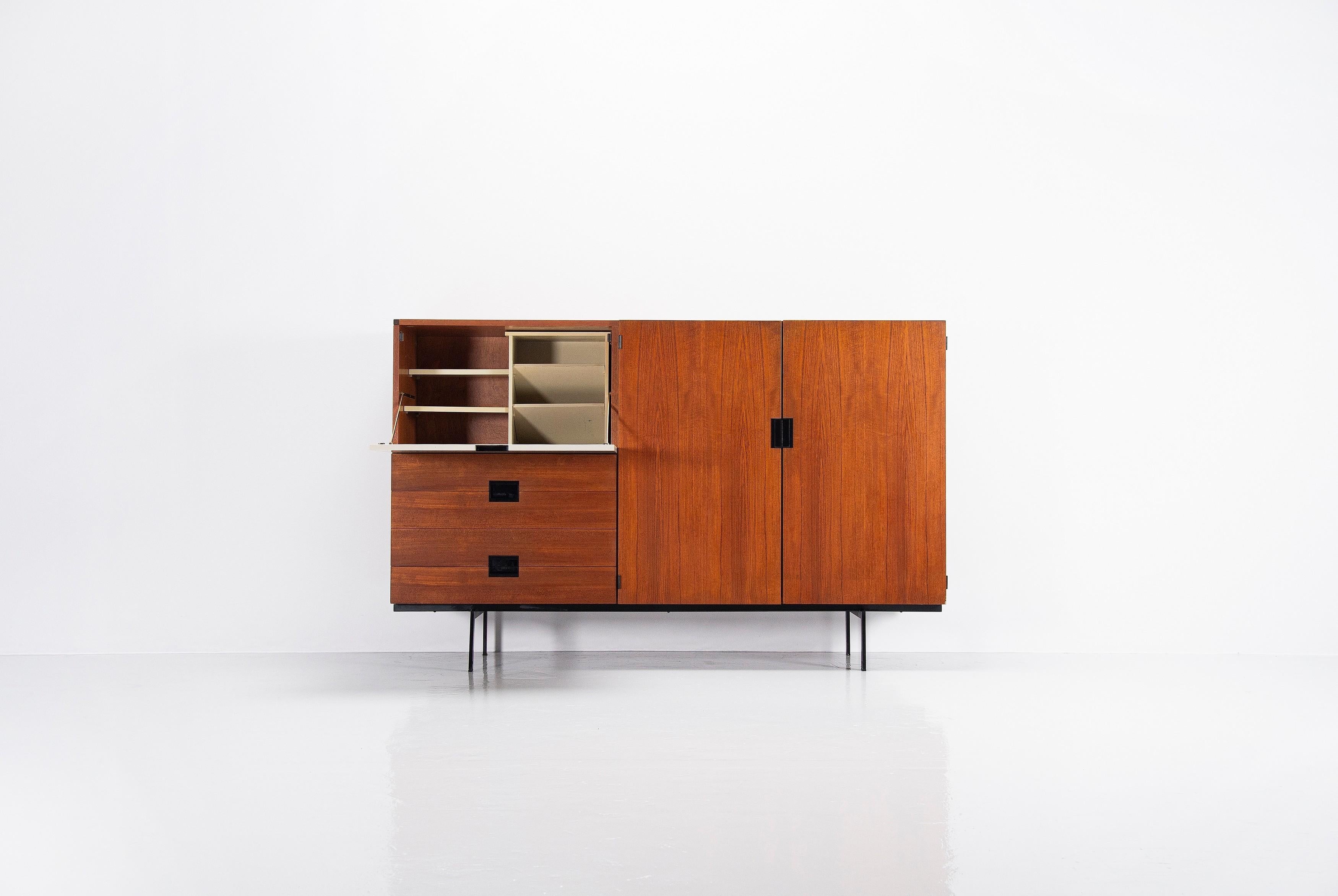 This is for a Minimalist cabinet model CU09 designed by Cees Braakman and manufactured by Pastoe UMS, Holland 1958. This high cabinet is made of teak wood and has a black painted metal frame. The handles are made of black plastic. The left folding