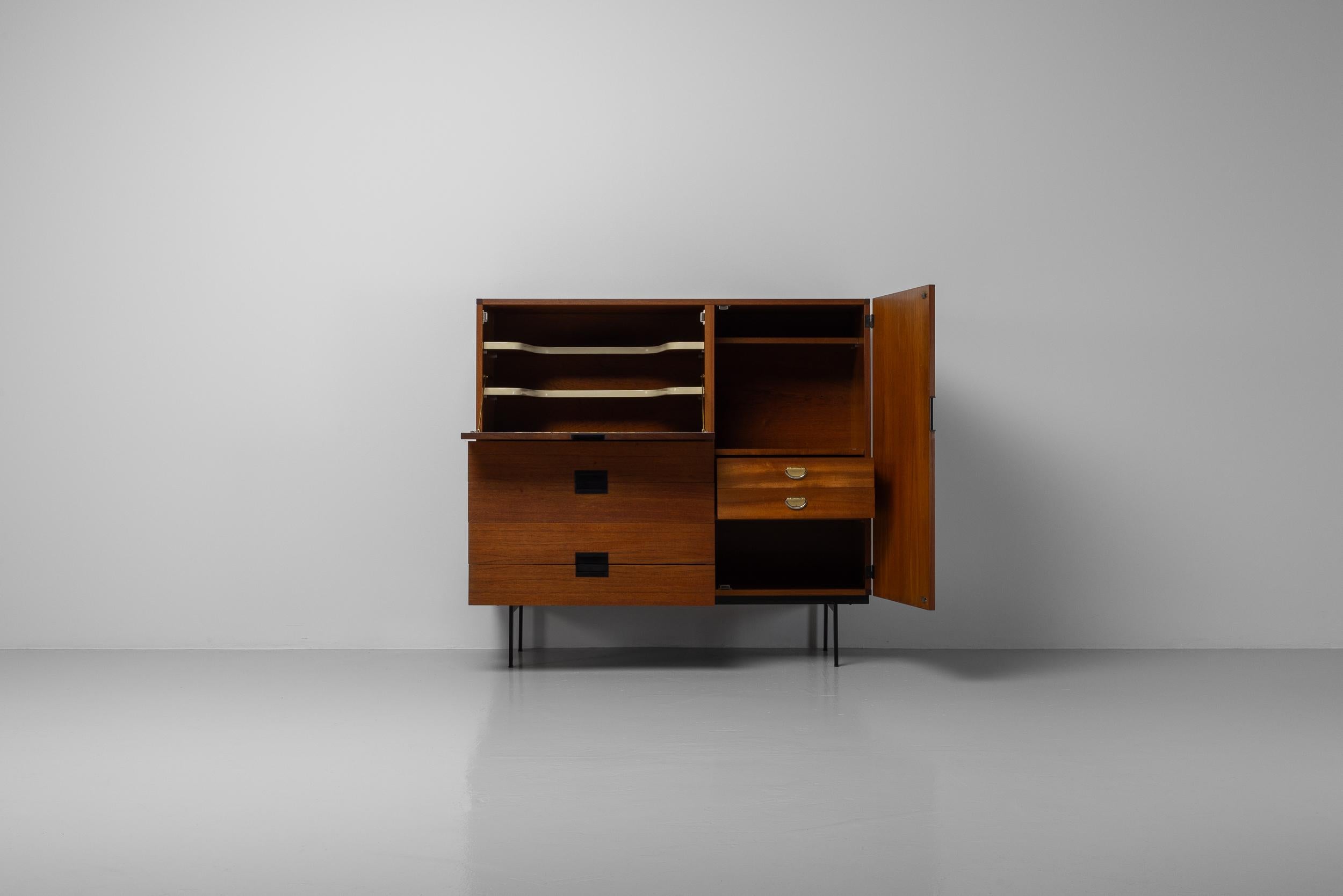 Magnifique armoire CU06 minimaliste conçue par Cees Braakman et fabriquée par Pastoe aux Pays-Bas en 1958. Une pièce magnifique en placage de bois de teck. L'armoire est également dotée d'un cadre en métal peint en noir. Les poignées des portes