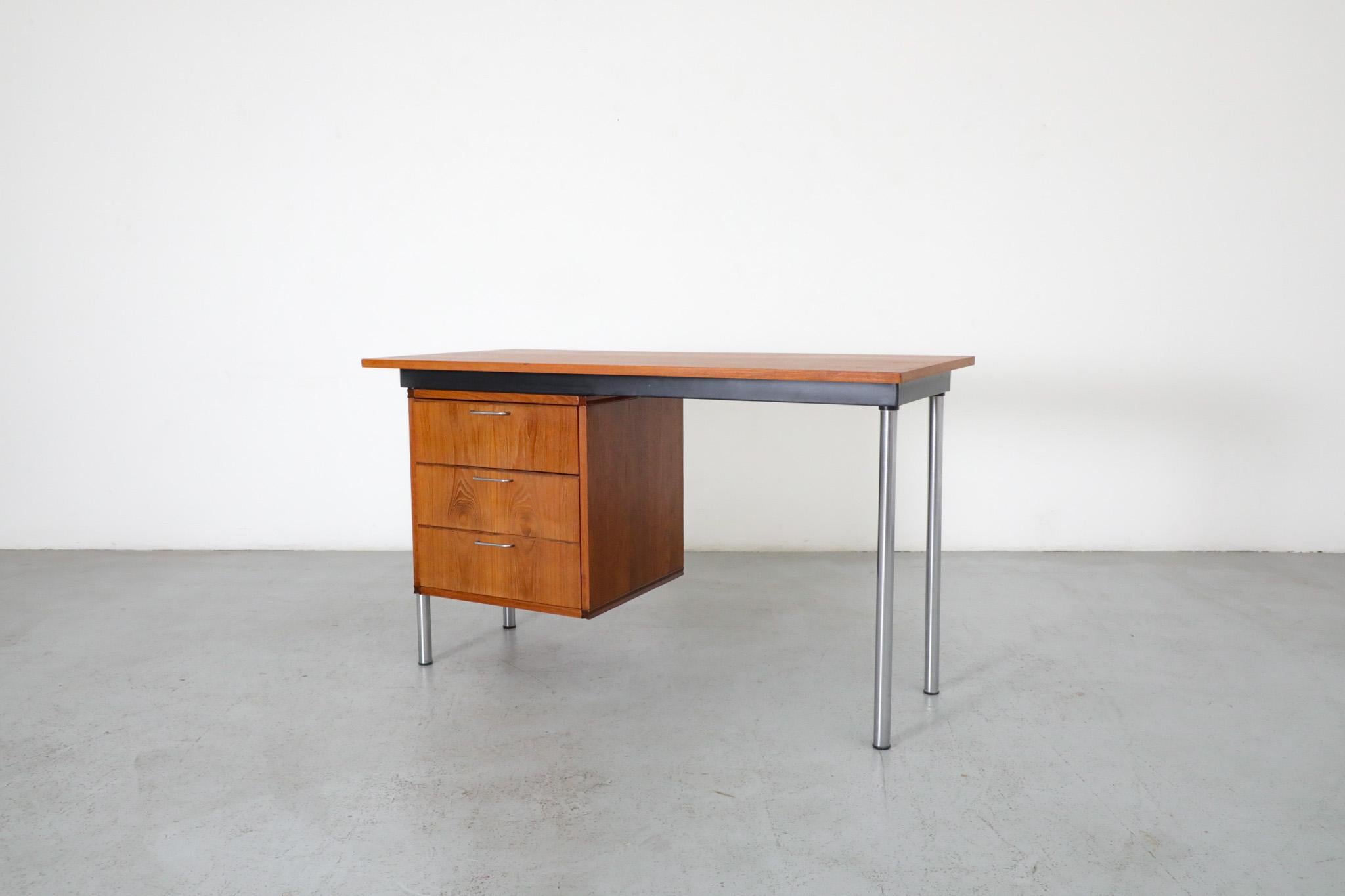 Part of Cees Braakman's 1956 Made to Measure Series for Pastoe, this Made to Measure teak desk has three drawers with elegantly curved interiors, chrome legs and drawer pulls, and a decorative black accent. In original condition with some visible